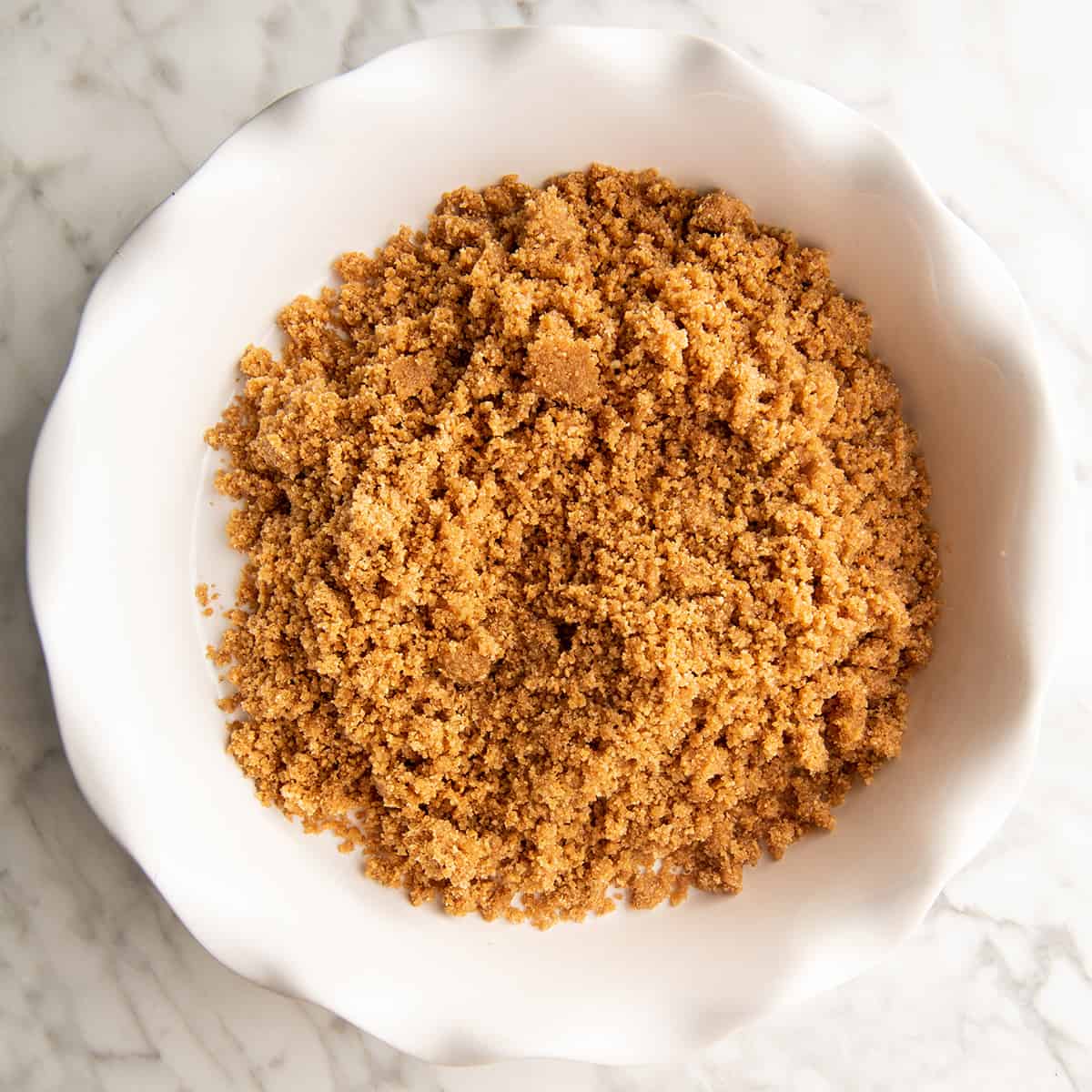 How to Make Graham Cracker Crust - pouring crust mixture into pie dish