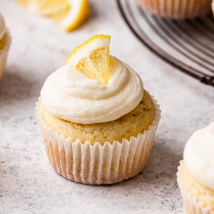 a lemon cupcake frosted with a slice of lemon on top