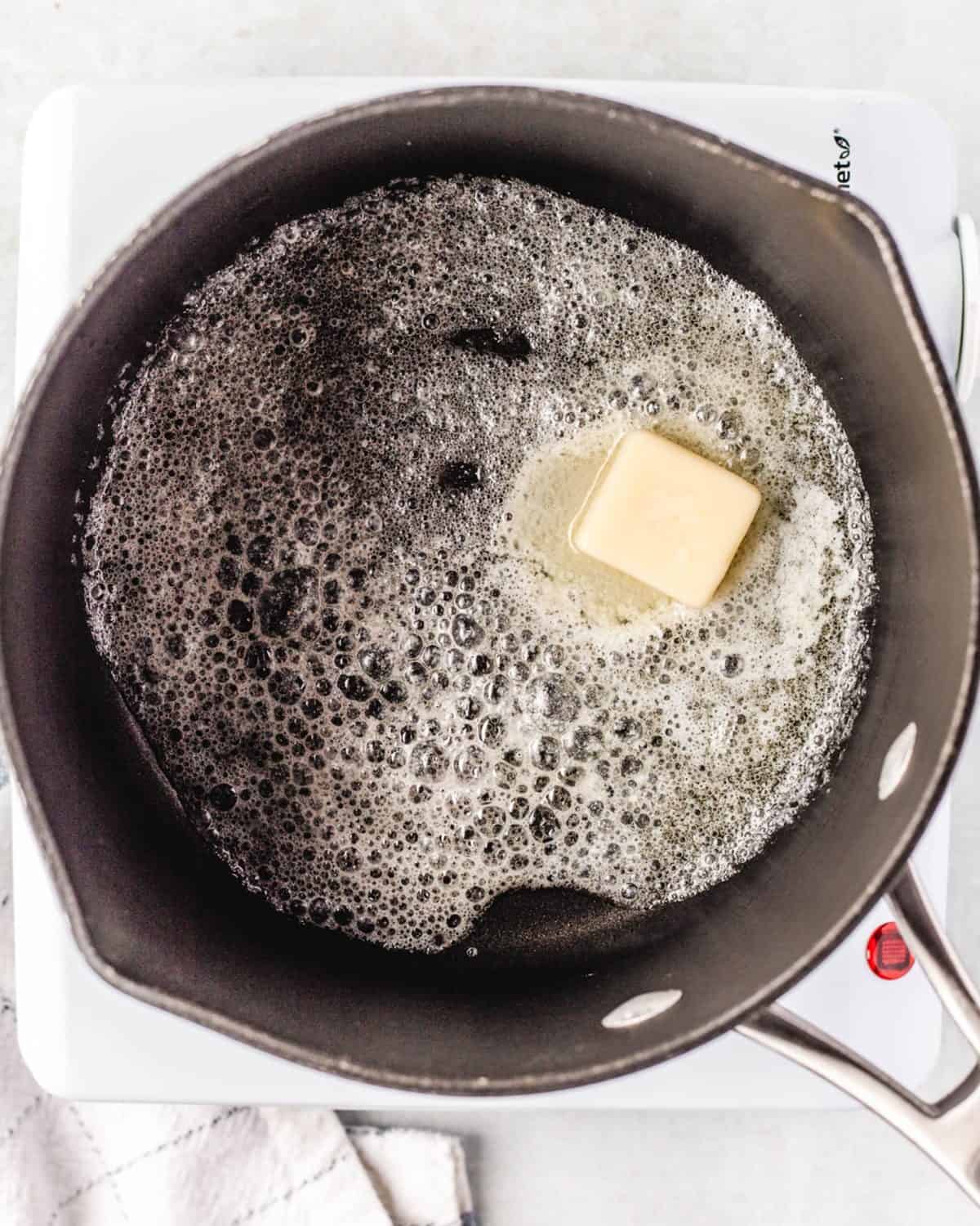 making mac and cheese cups - butter melting in a cast iron skillet