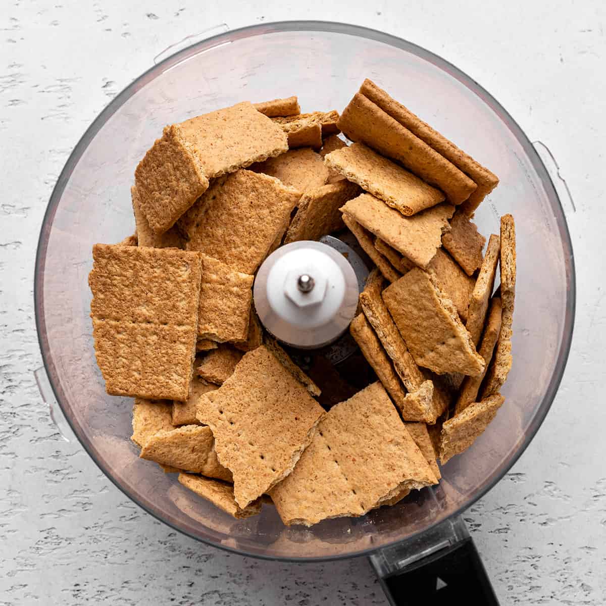 graham crackers in a food processor making the crust for this No Bake Cheesecake Recipe