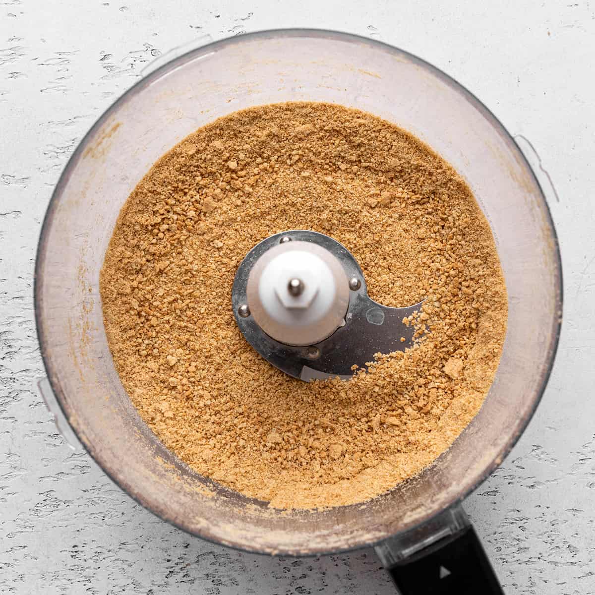 graham cracker crumbs in a food processor to make the crust for this No Bake Cheesecake Recipe