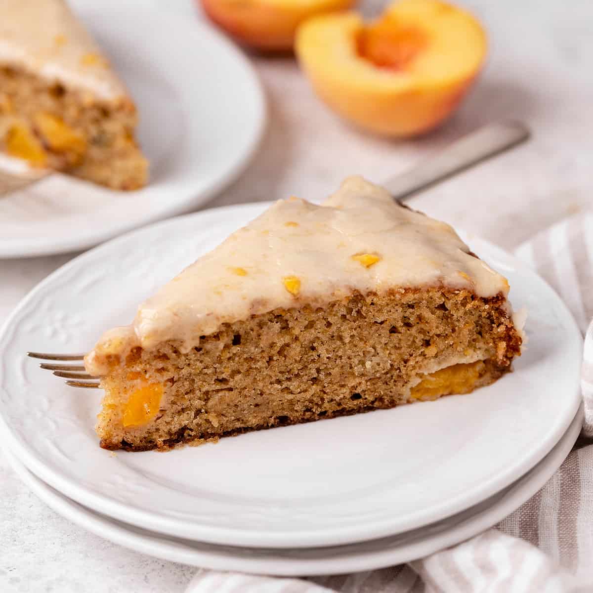 a slice of peach cake on a plate with a fork