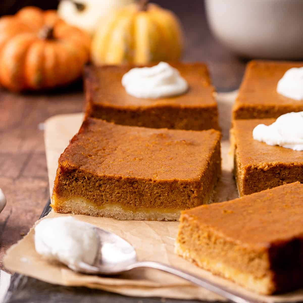 5 Pumpkin Pie Bars cut into squares, 3 with whipped cream on top
