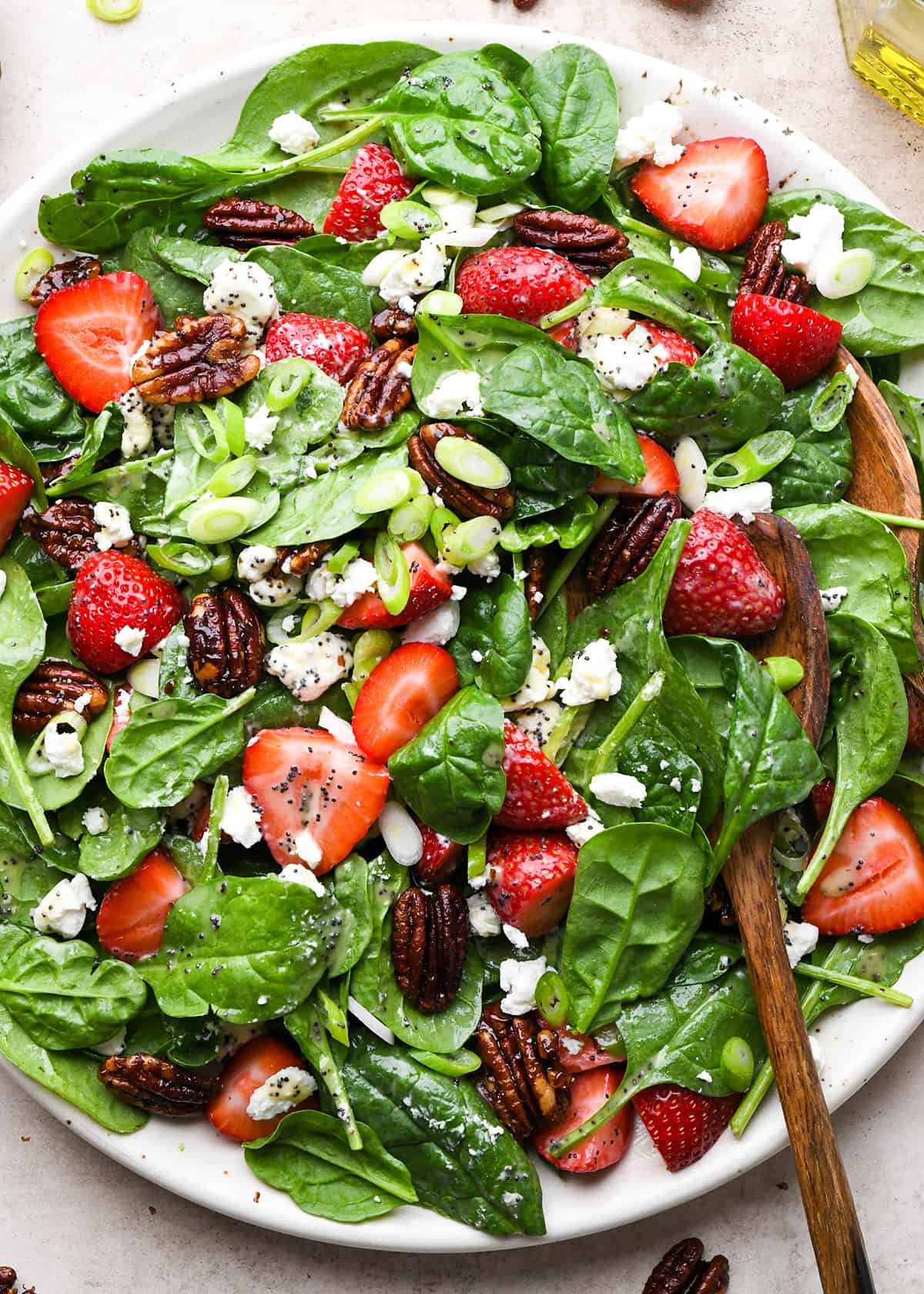 Strawberry Spinach Salad Recipe on a serving plate with salad servers
