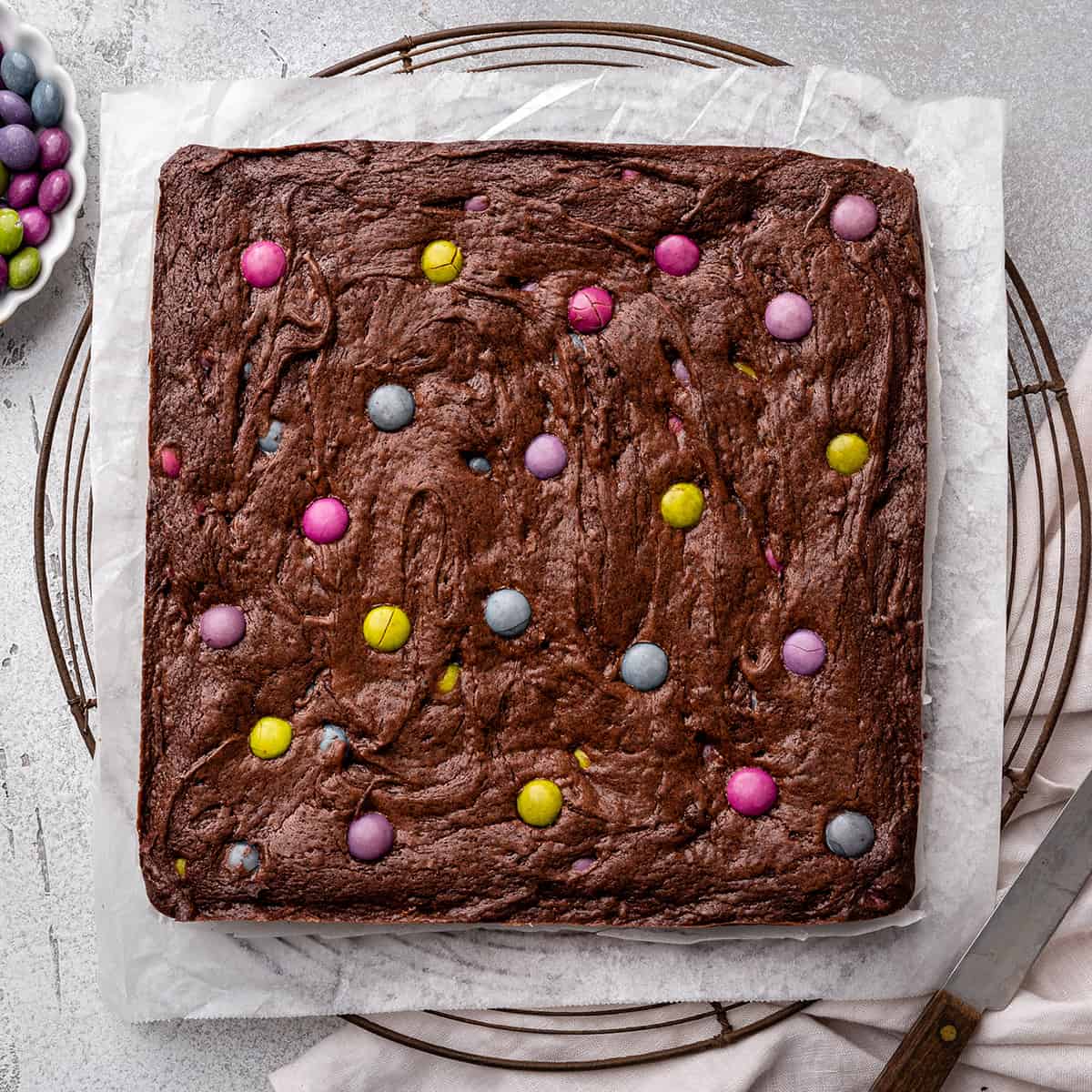 m and m brownies on a wire cooling rack
