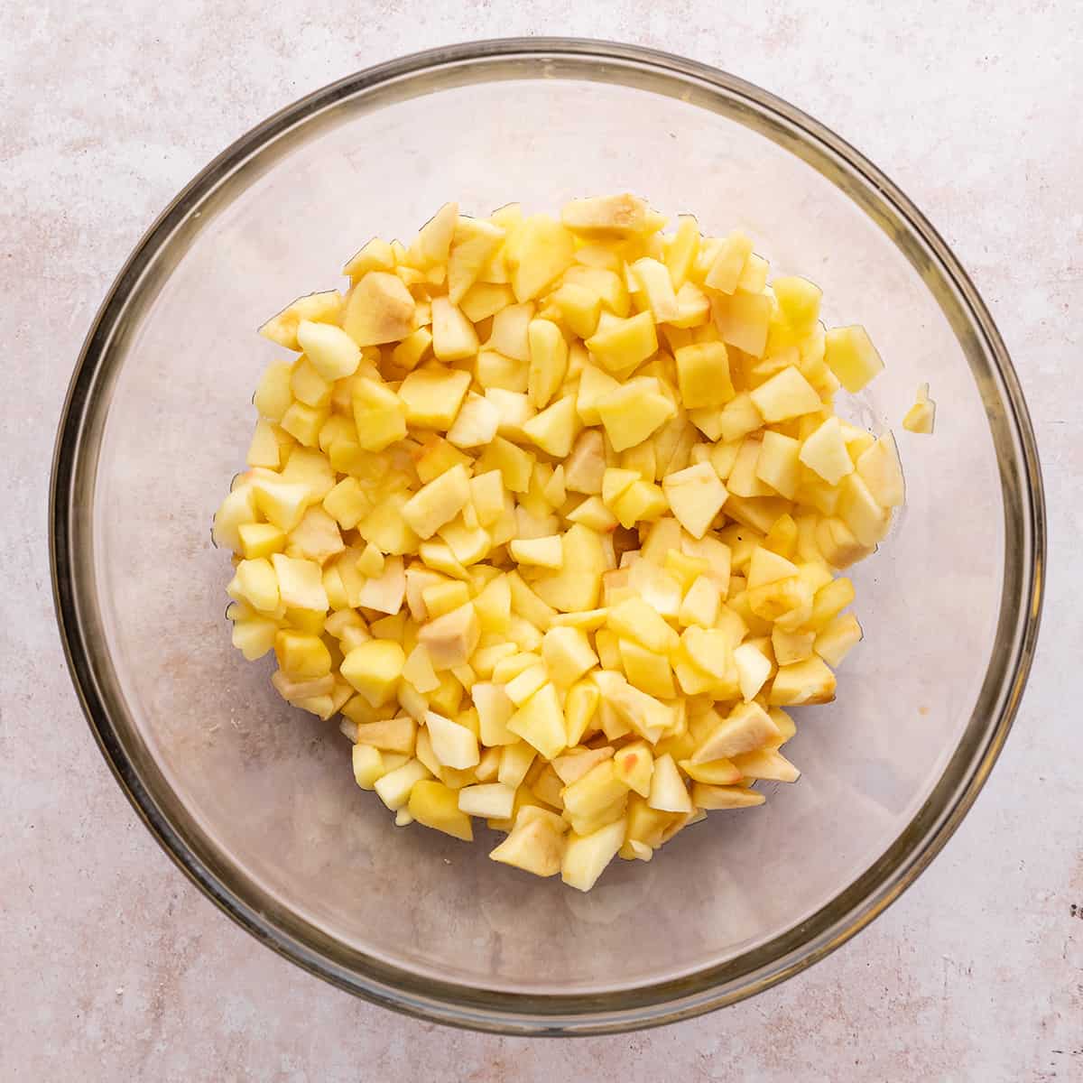 peeled, diced and partially cooked apples in a glass bowl