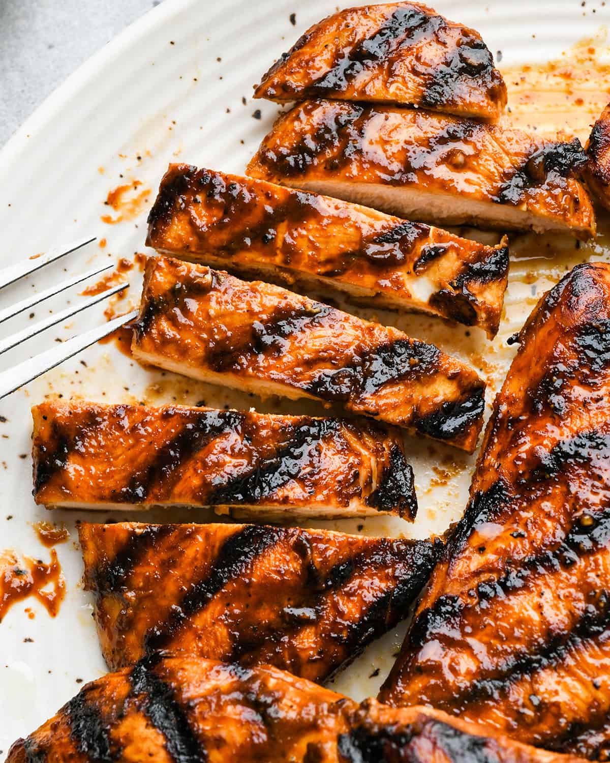 a grilled bbq chicken breast cut into strips