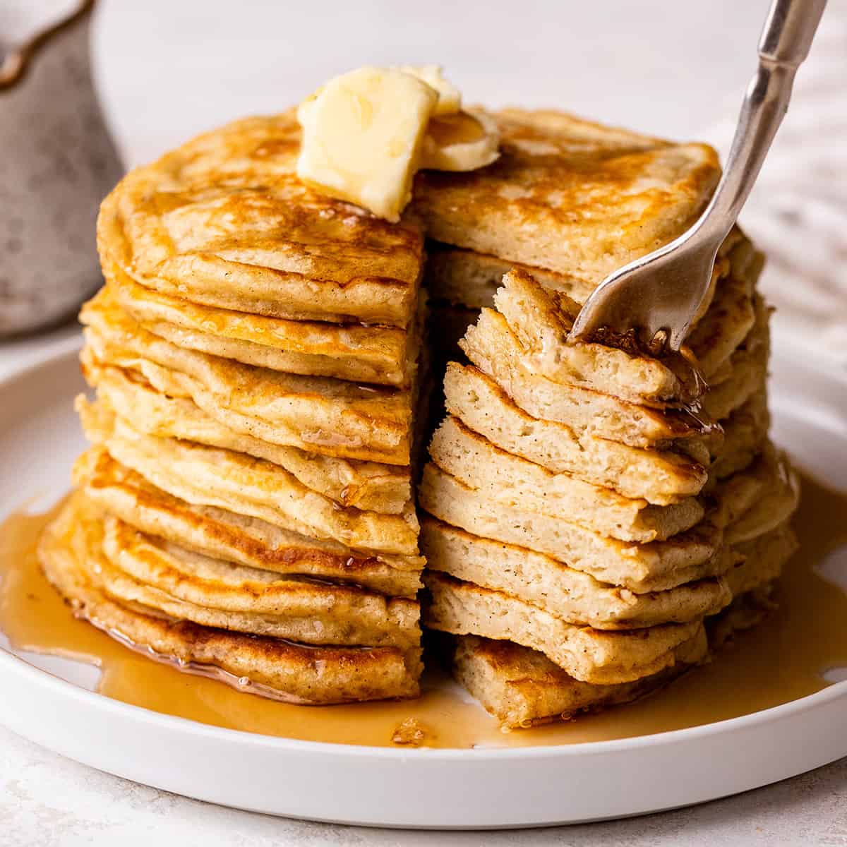 a fork taking a bite of a stack of 8 Buttermilk Pancakes