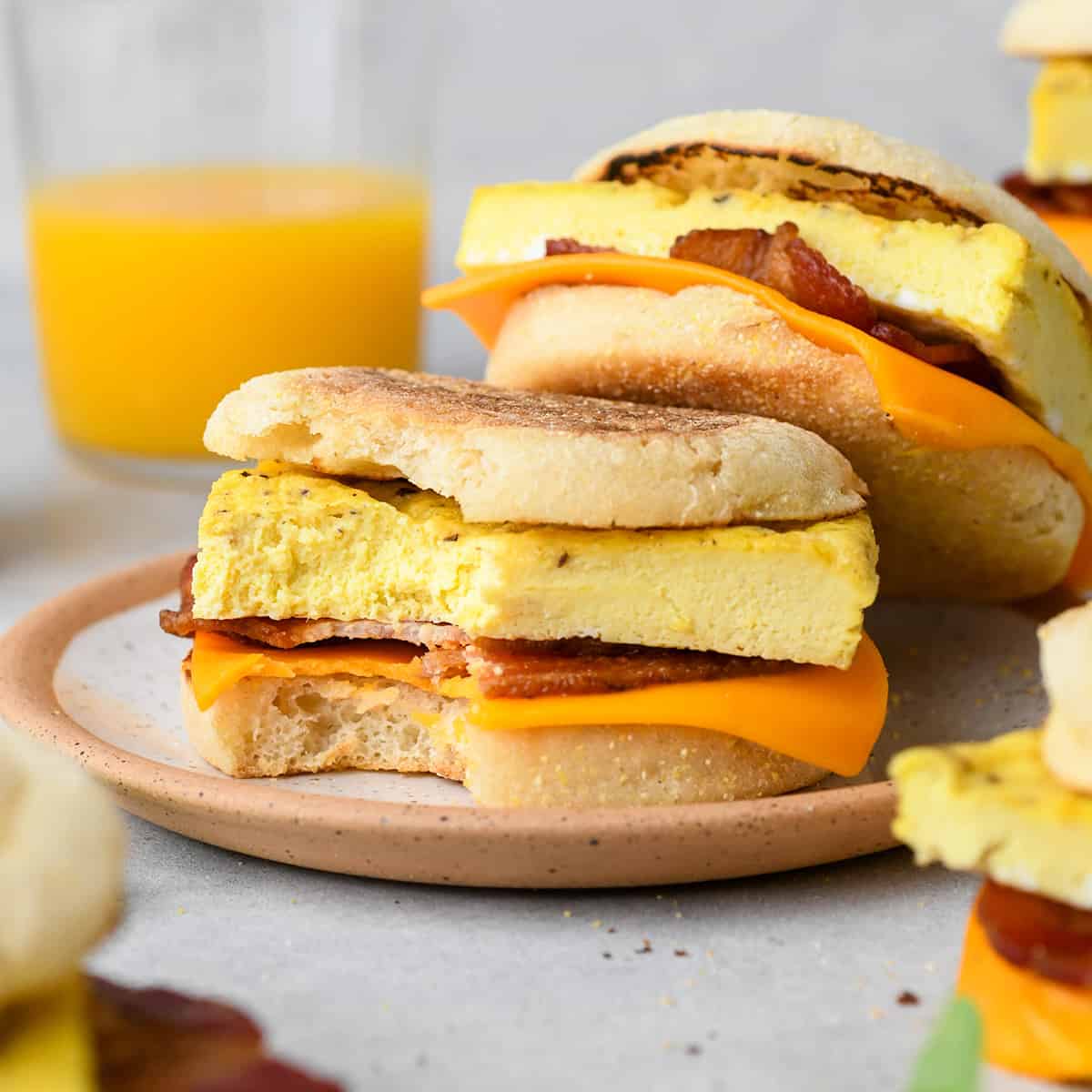 2 Breakfast Egg Sandwiches on a plate, one with a bite taken out of it