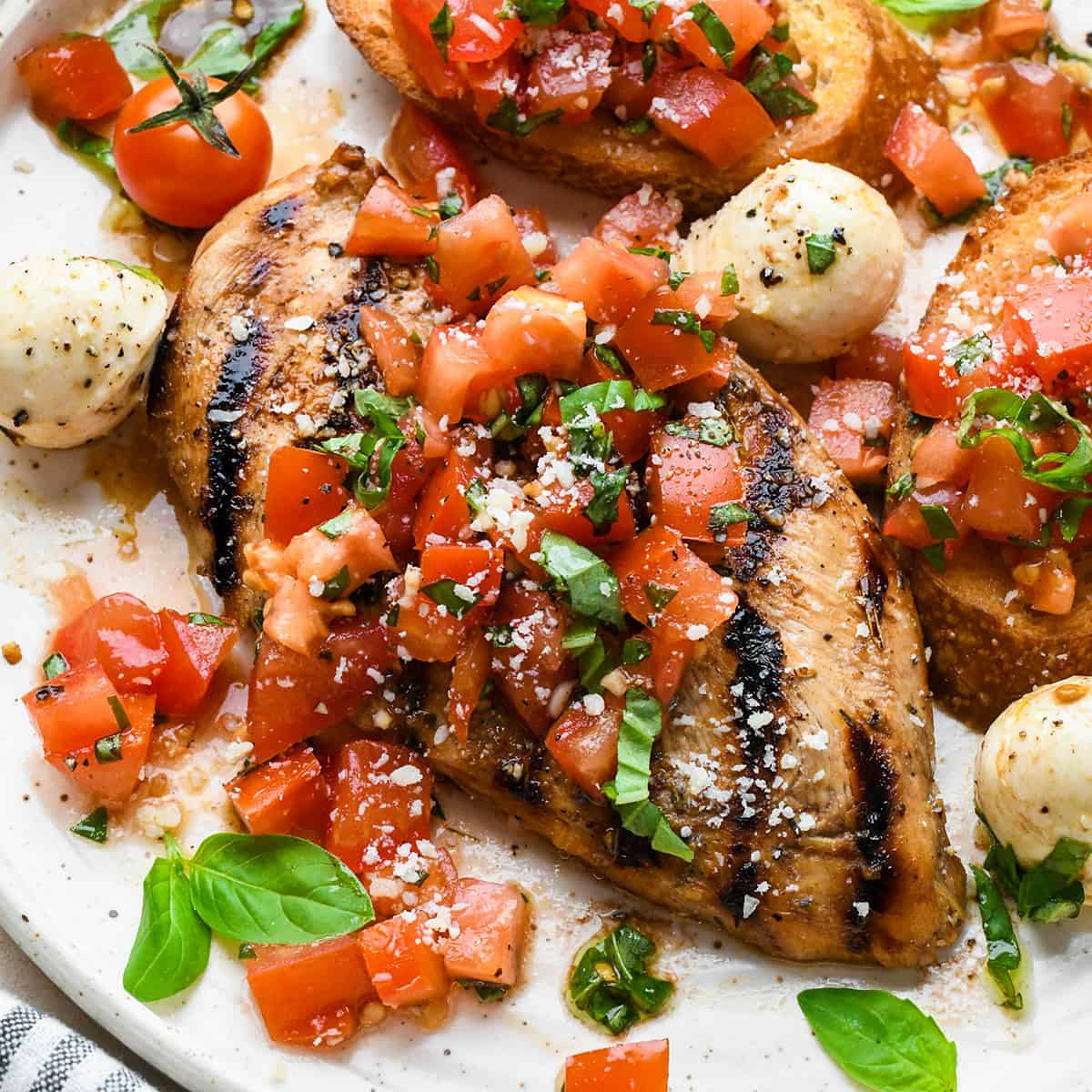 Bruschetta Chicken on a serving plate with mozzarella cheese