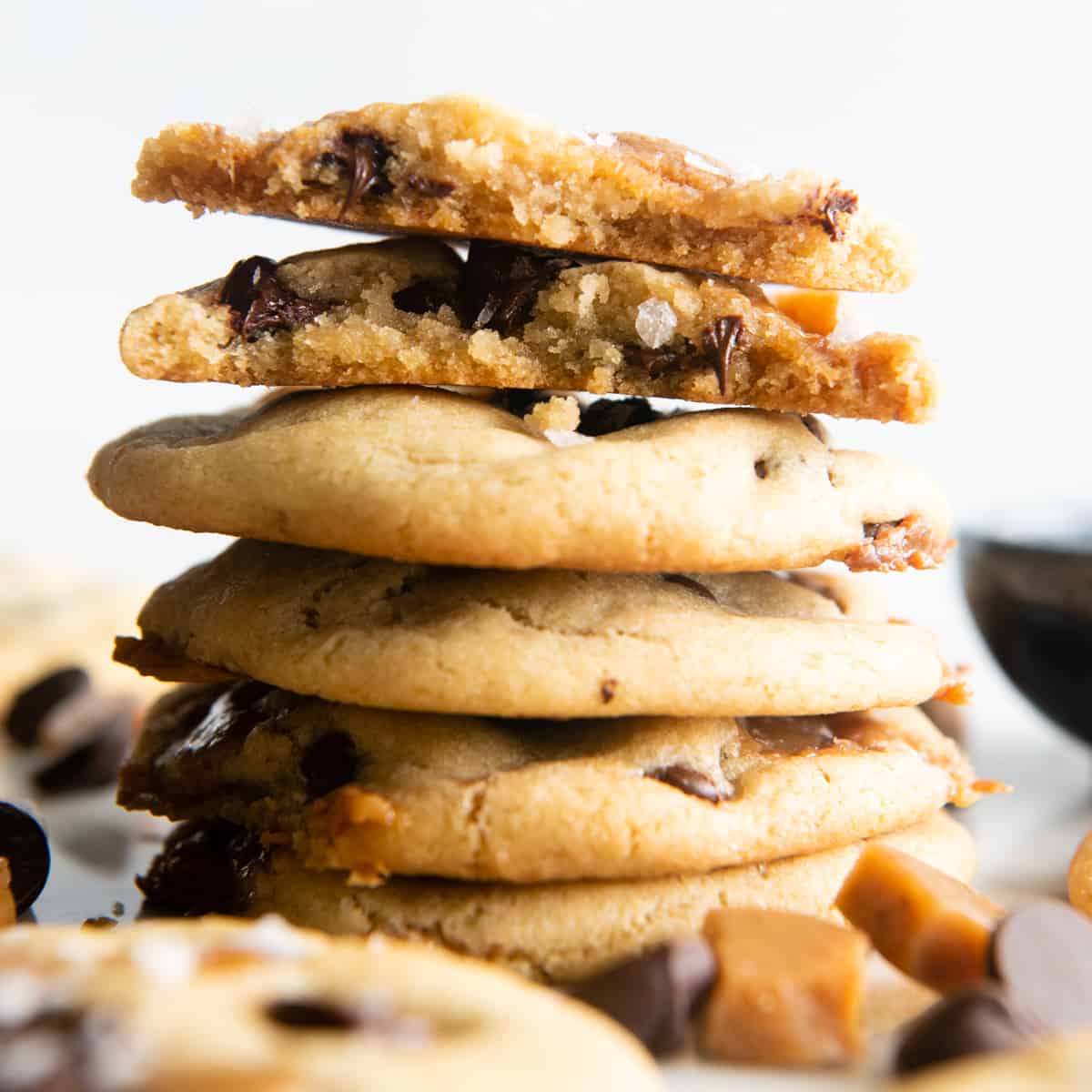 a stack of 5 Chocolate Chip Caramel Cookies, the top one is broken in half so you can see the inside