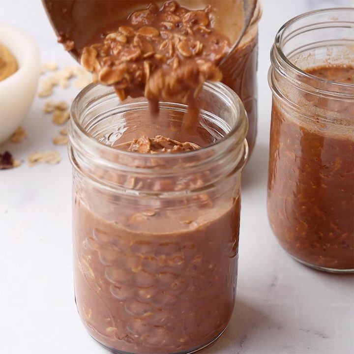 Chocolate Peanut Butter Overnight Oats being poured into glass jars