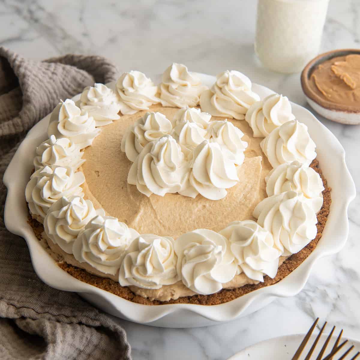a No-Bake Peanut Butter Pie decorated with whipped cream