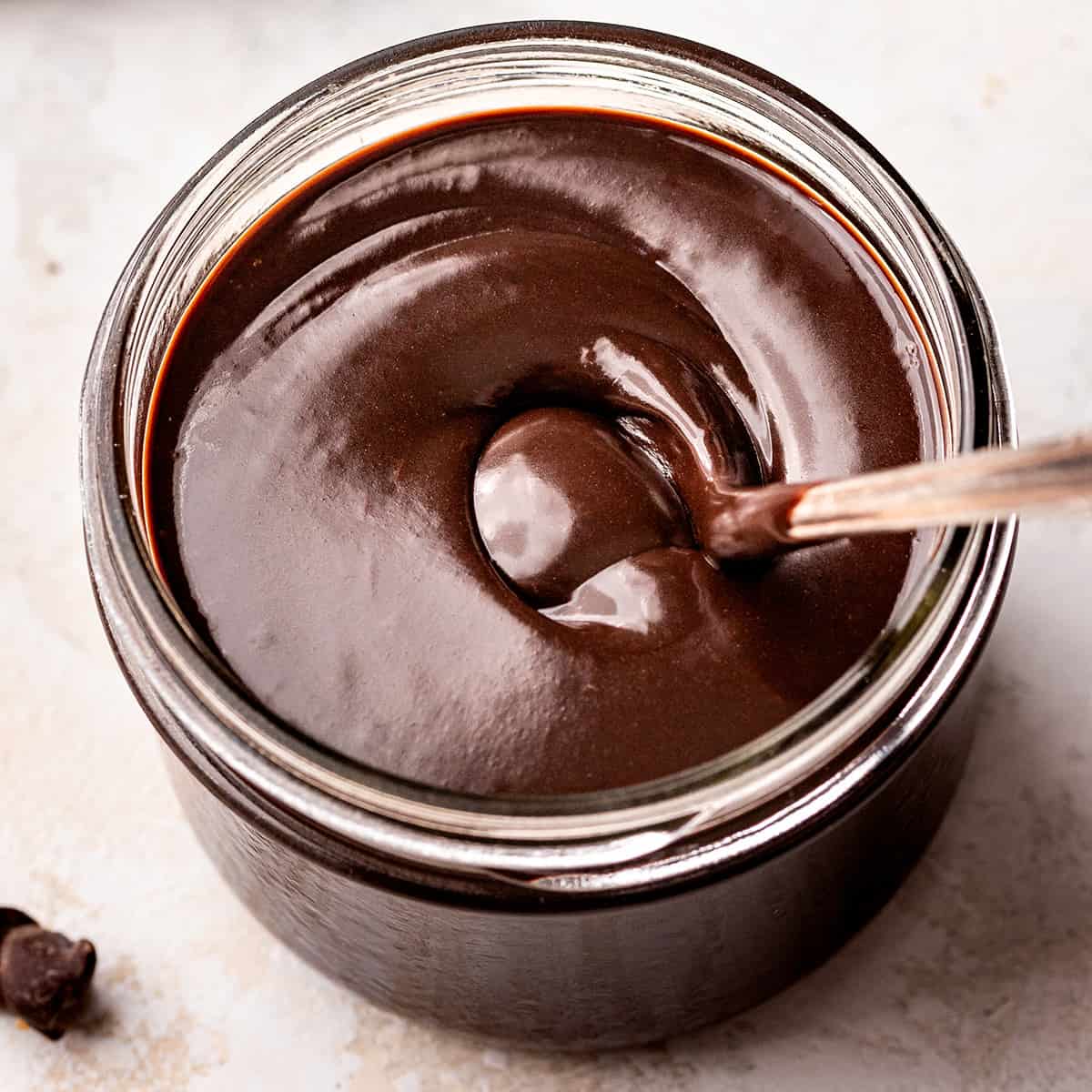 Chocolate Sauce in a glass jar with a spoon 