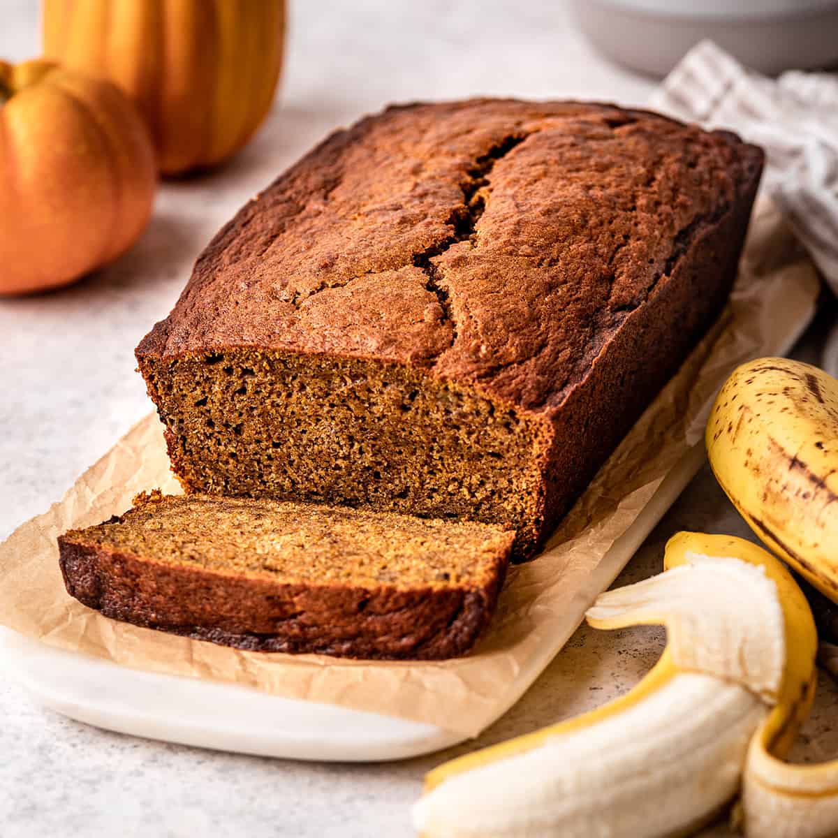 front view of a loaf of Pumpkin Banana Bread with one slice cut out of it