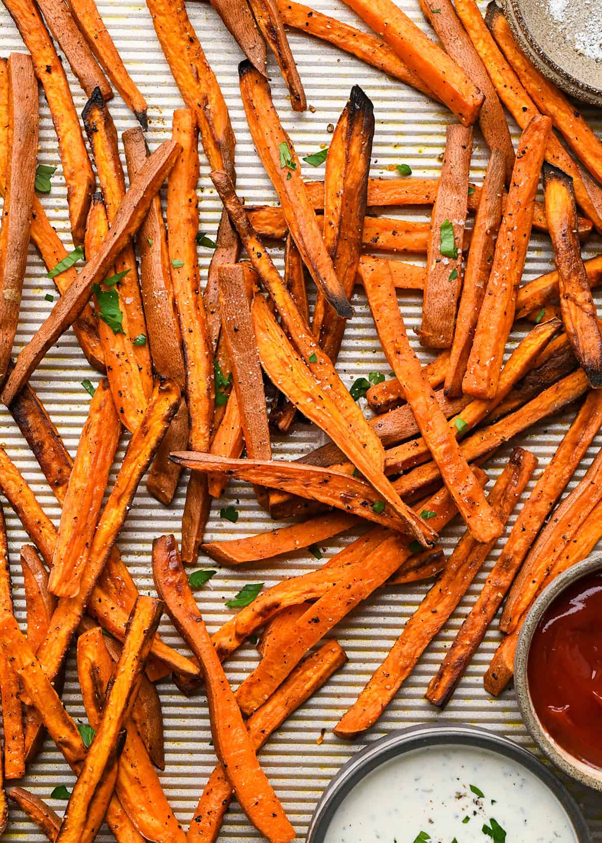 Baked Sweet Potato Fries on a baking sheet with two dipping sauces