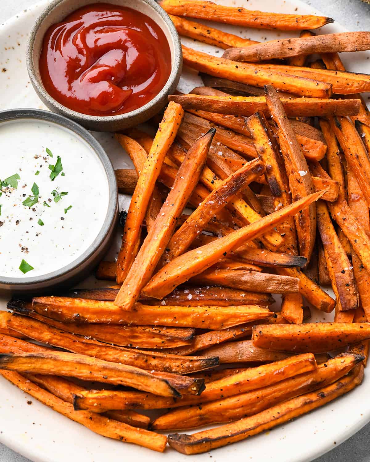 up close photo of Baked Sweet Potato Fries with two dipping sauces