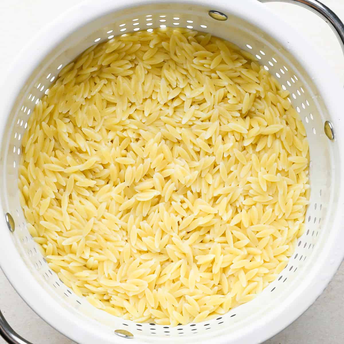 cooked orzo in a white strainer