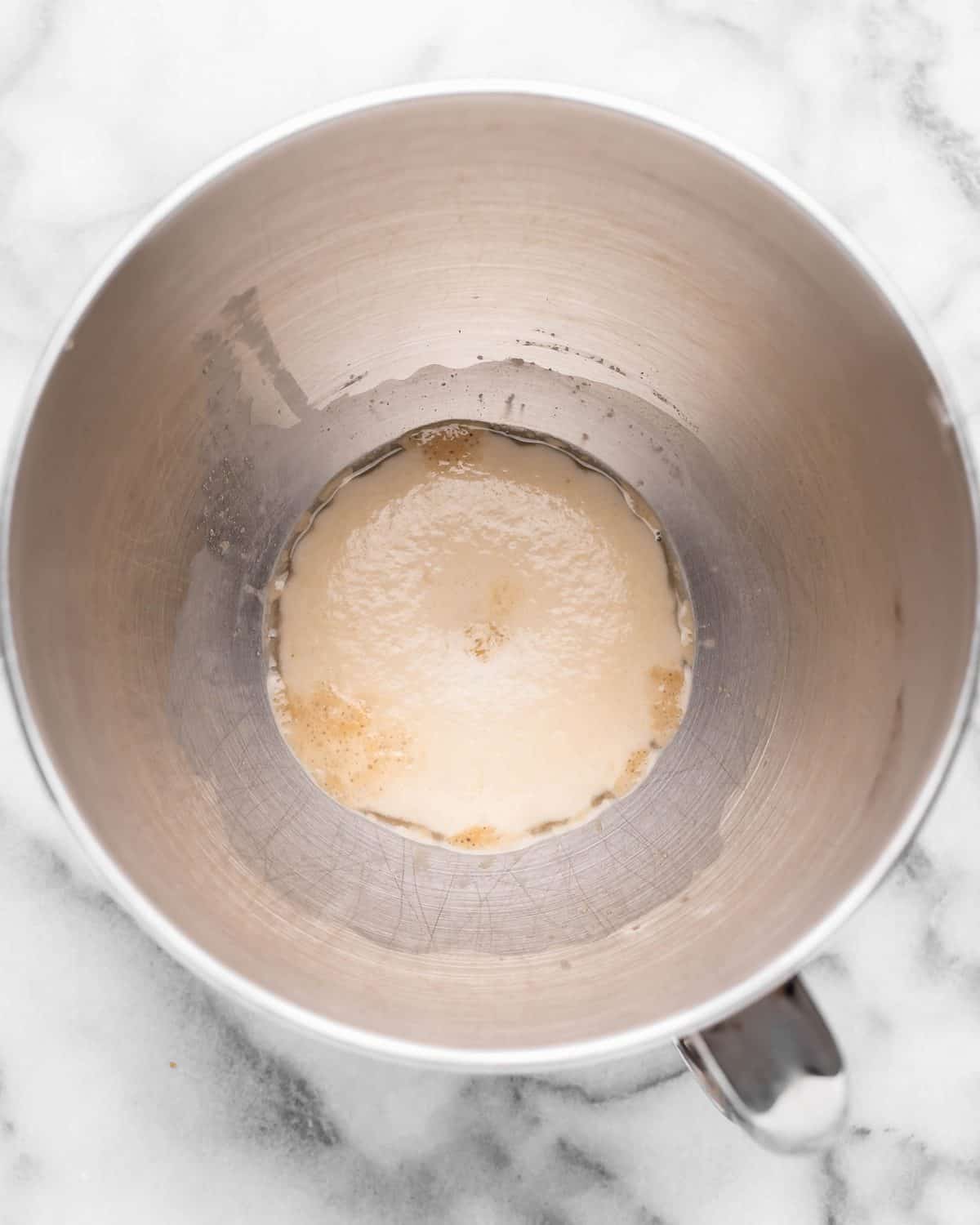 making chocolate cinnamon rolls - yeast, water and sugar proofing in a metal mixing bowl after yeast has proofed so it's foamy.