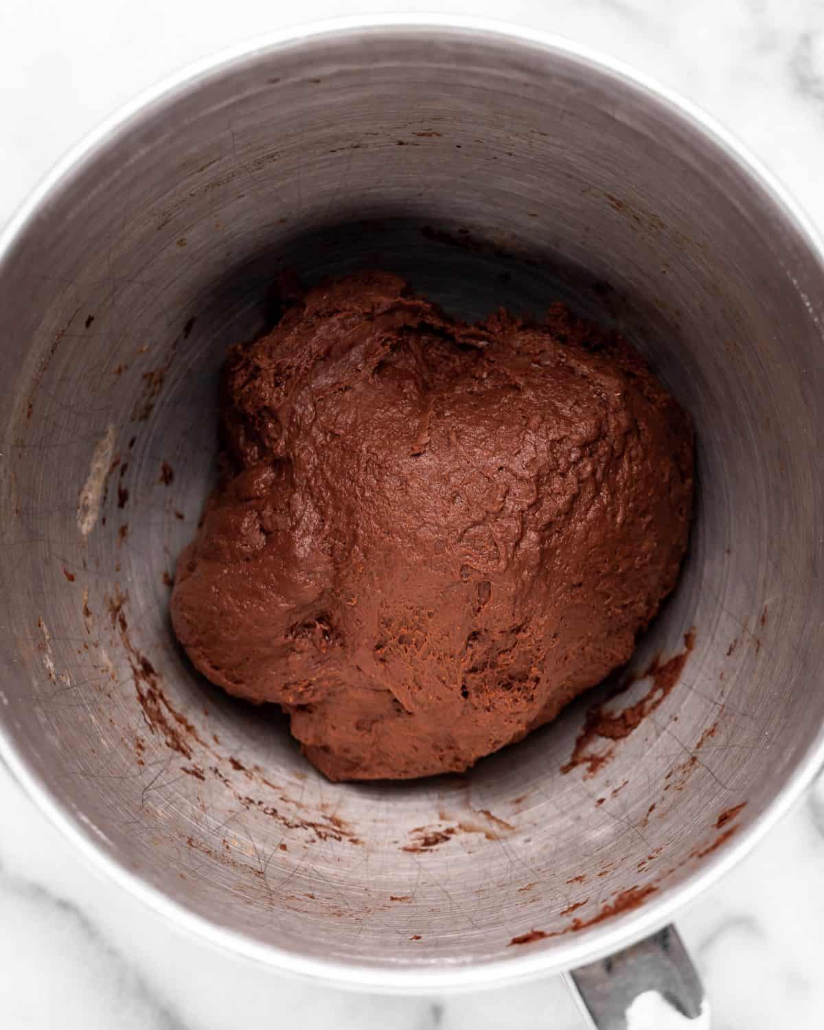 making chocolate cinnamon rolls - dough in a metal mixing bowl on a marble surface