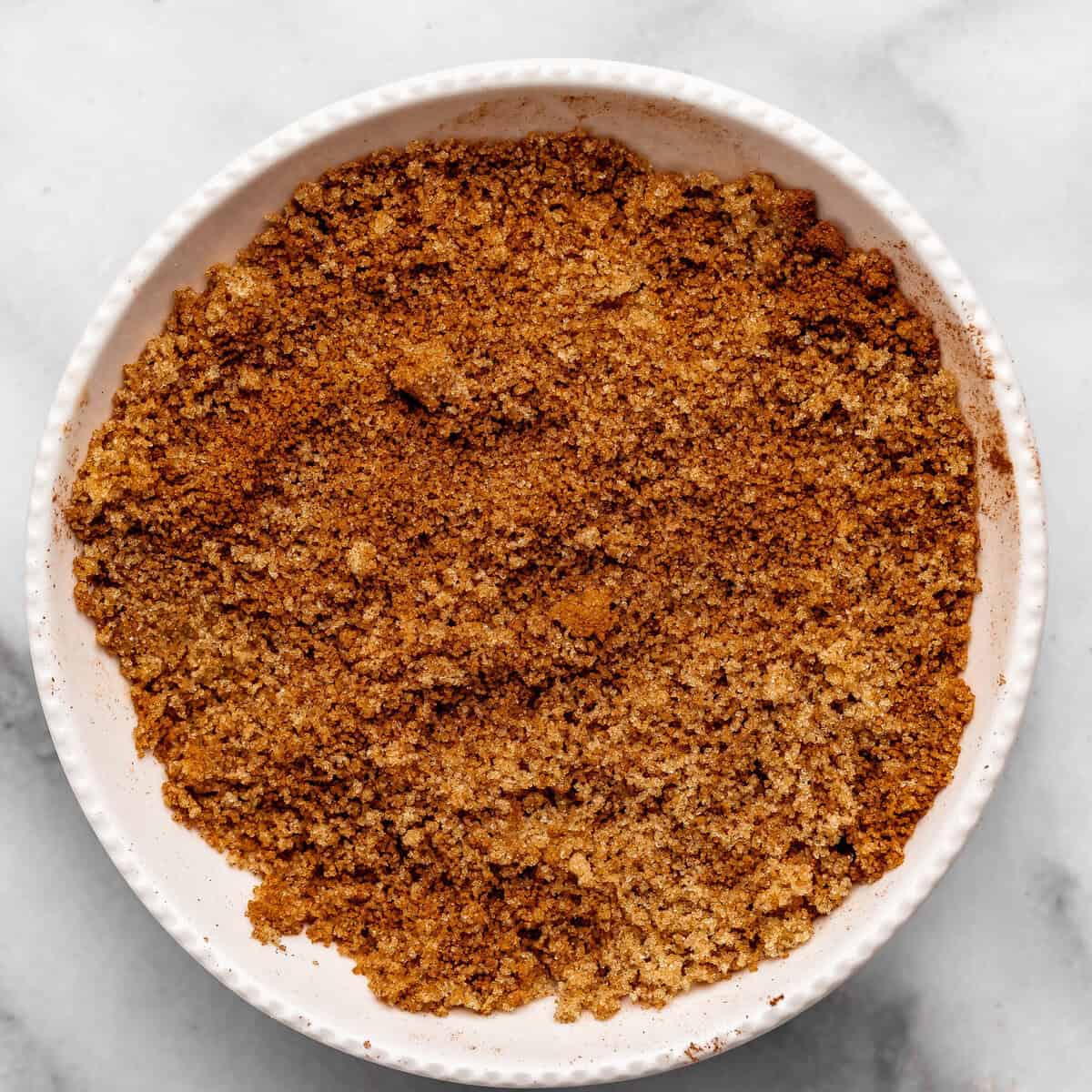 making chocolate cinnamon rolls - cinnamon and sugar filling mixed together in a white bowl on a metal surface