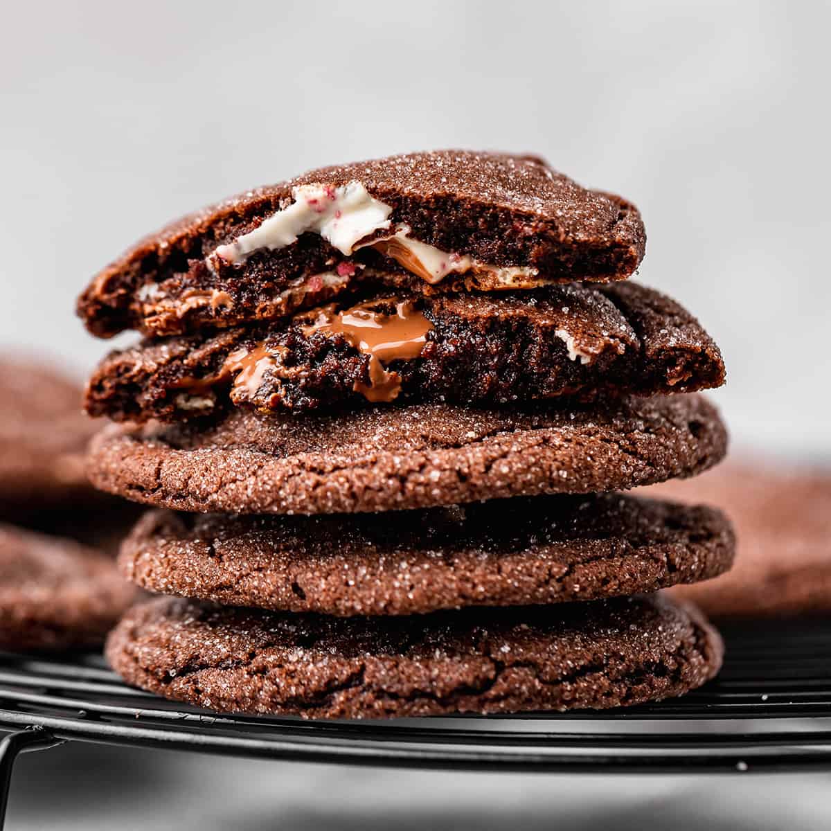 a stack of 4 Chocolate Peppermint Cookies, the top one is cut in half so the gooey insides of both halves are showing