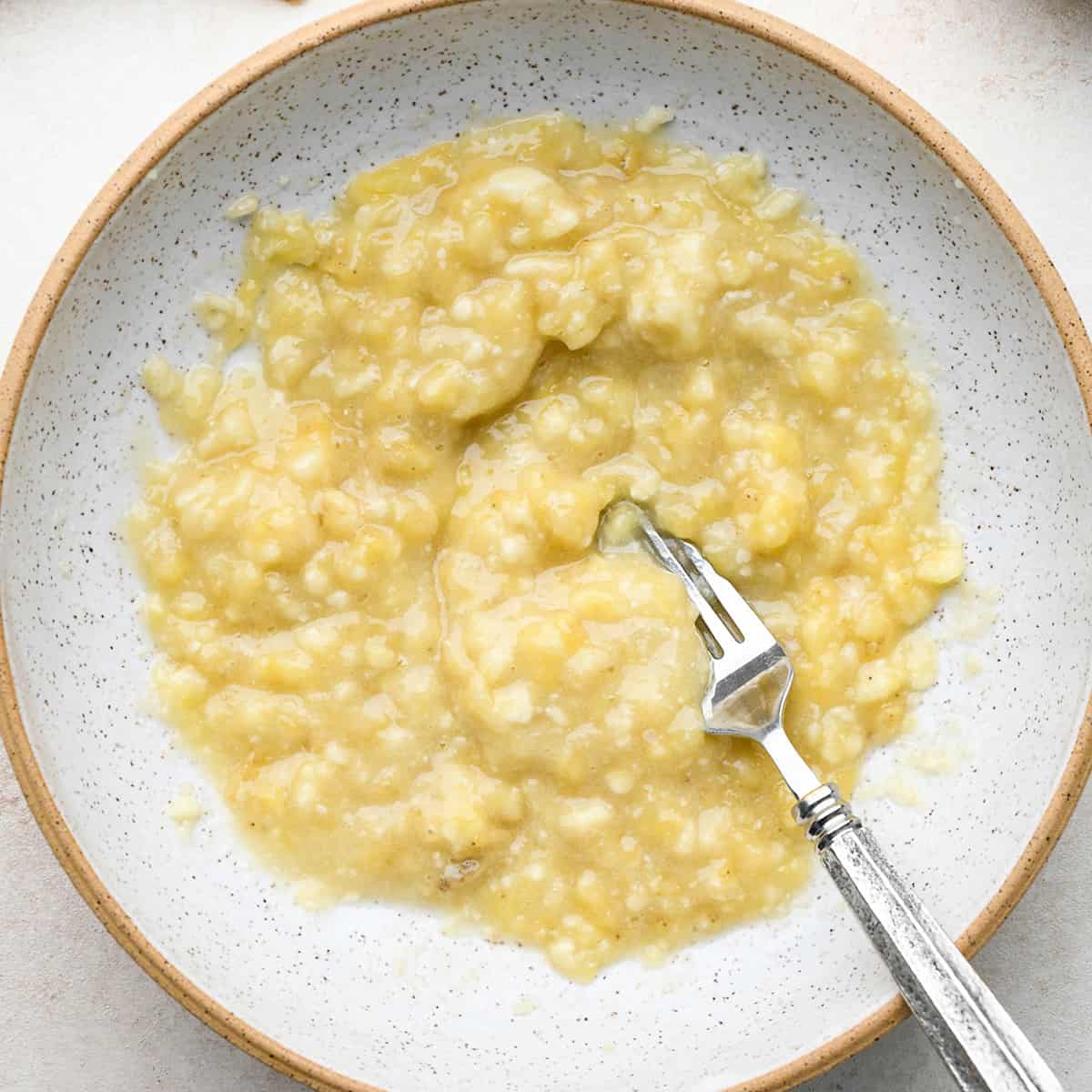 mashed banana in a bowl with a fork