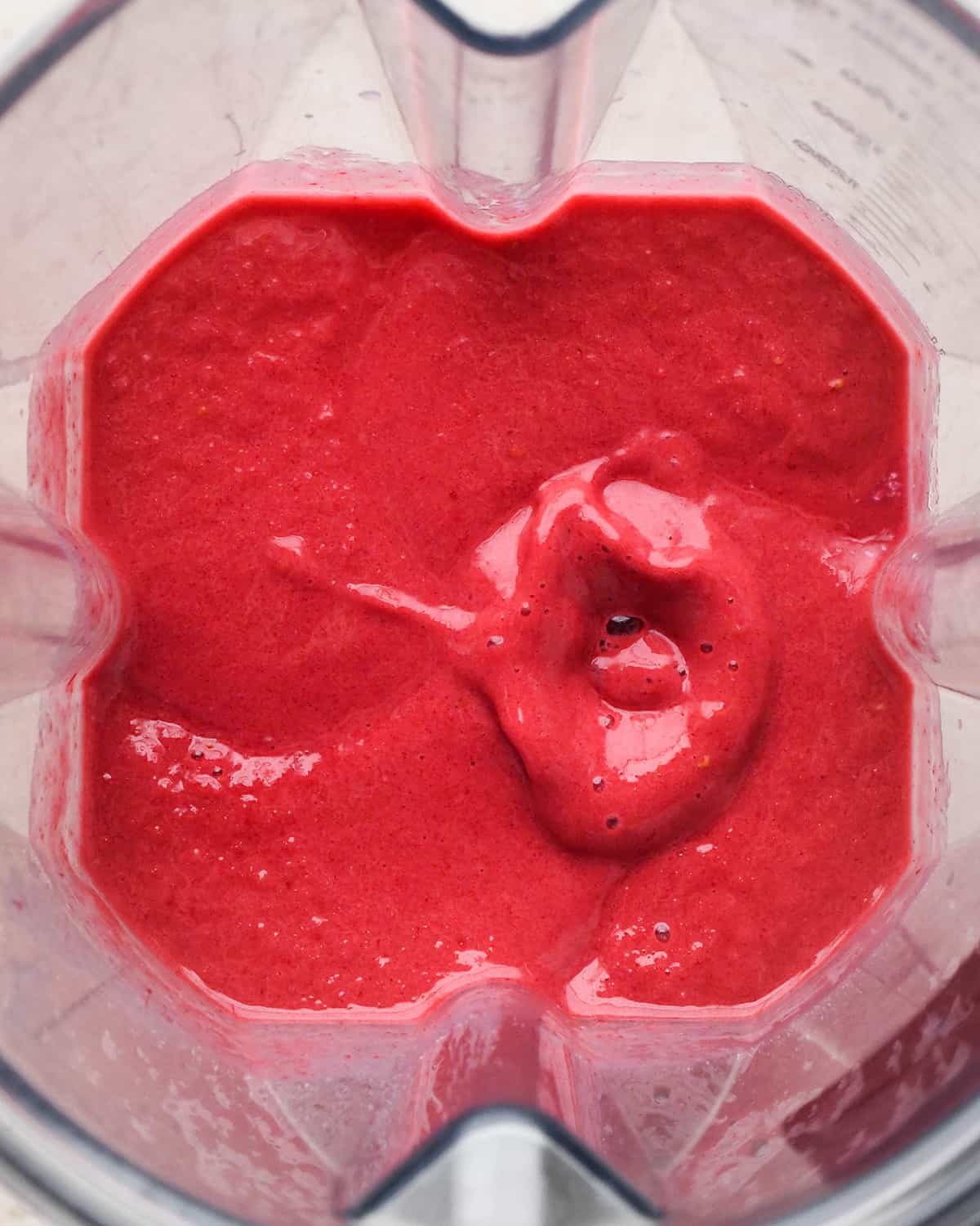 overhead photo of the ingredients in this Raspberry Smoothie in a blending container after blending