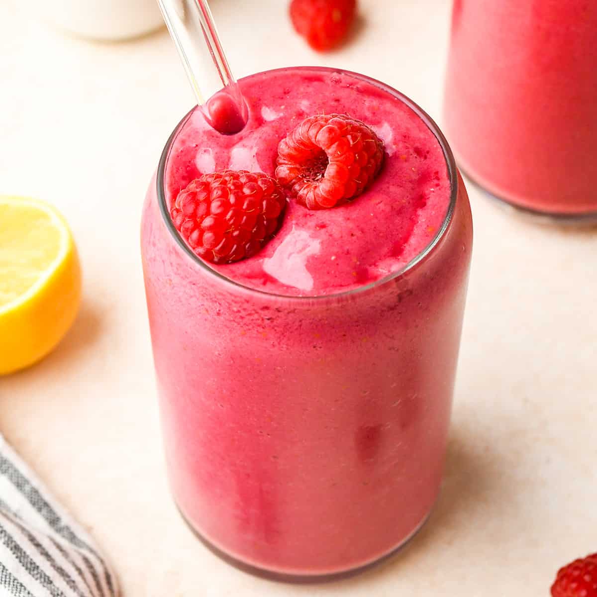Raspberry Smoothie in a glass topped with 2 raspberries