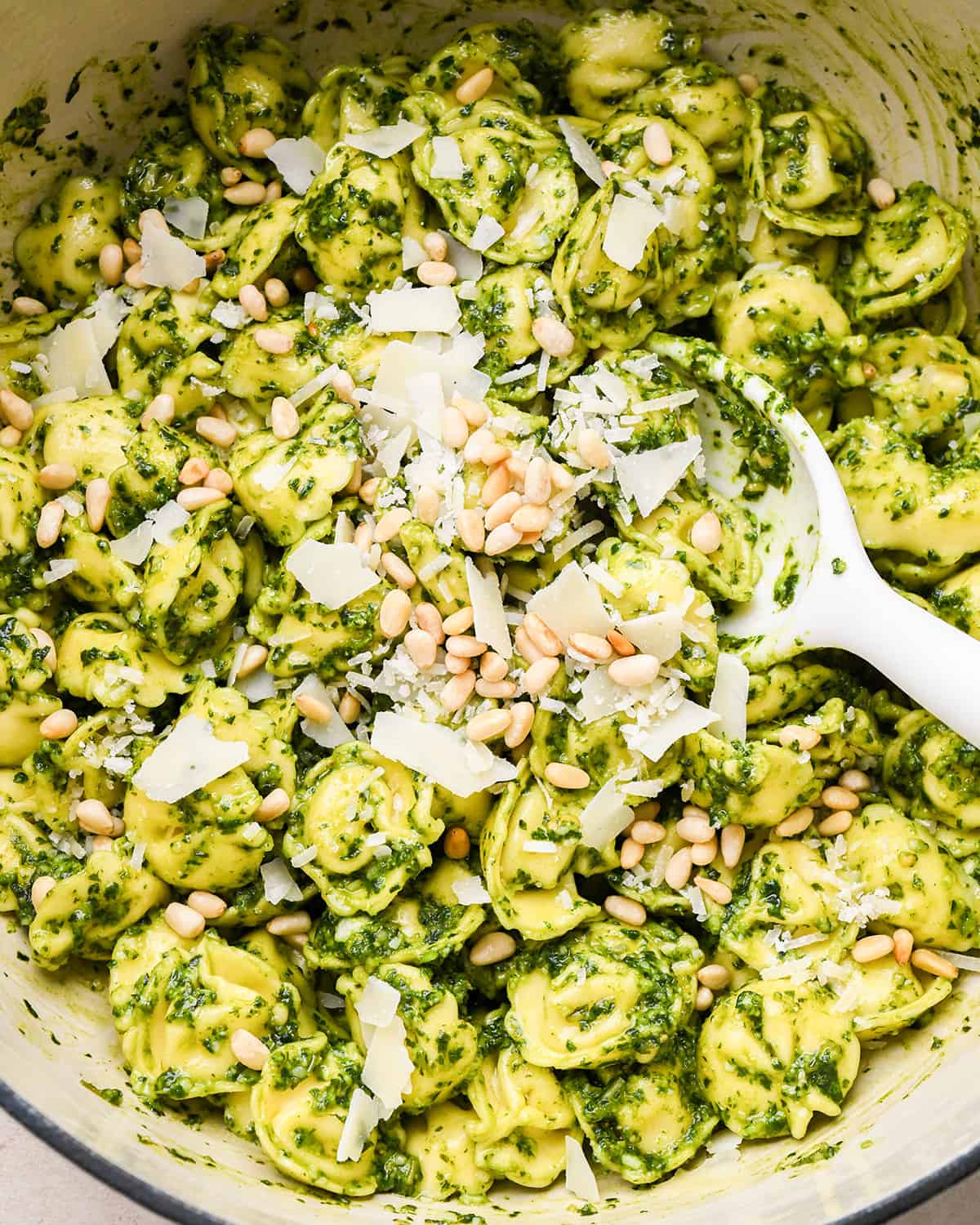 pesto tortellini topped with parmesan and pine nuts 