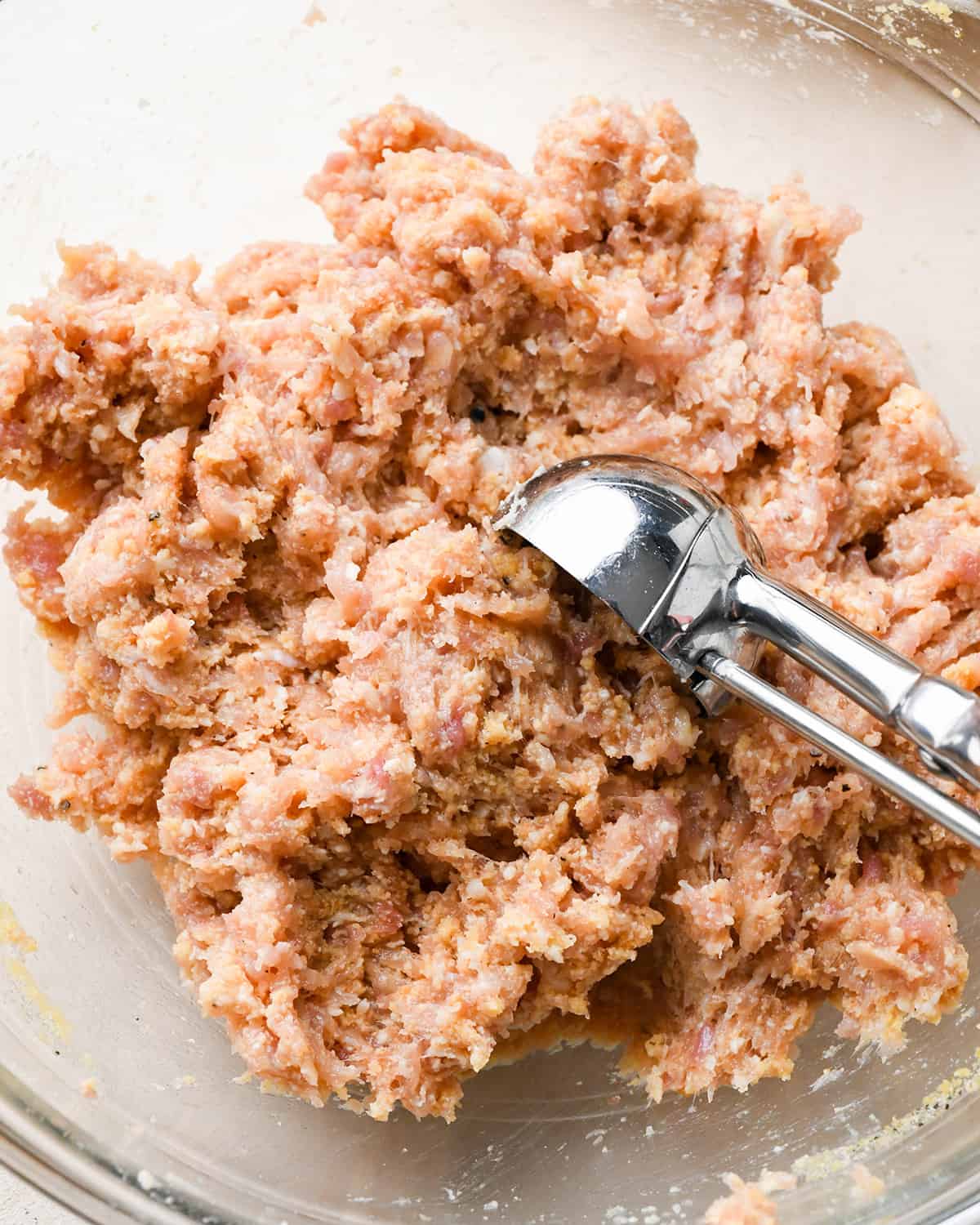 portioning out the chicken meatball mixture with a metal scoop