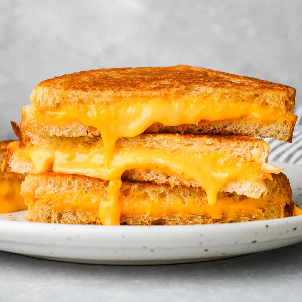  a stack of three halves of a grilled cheese sandwich