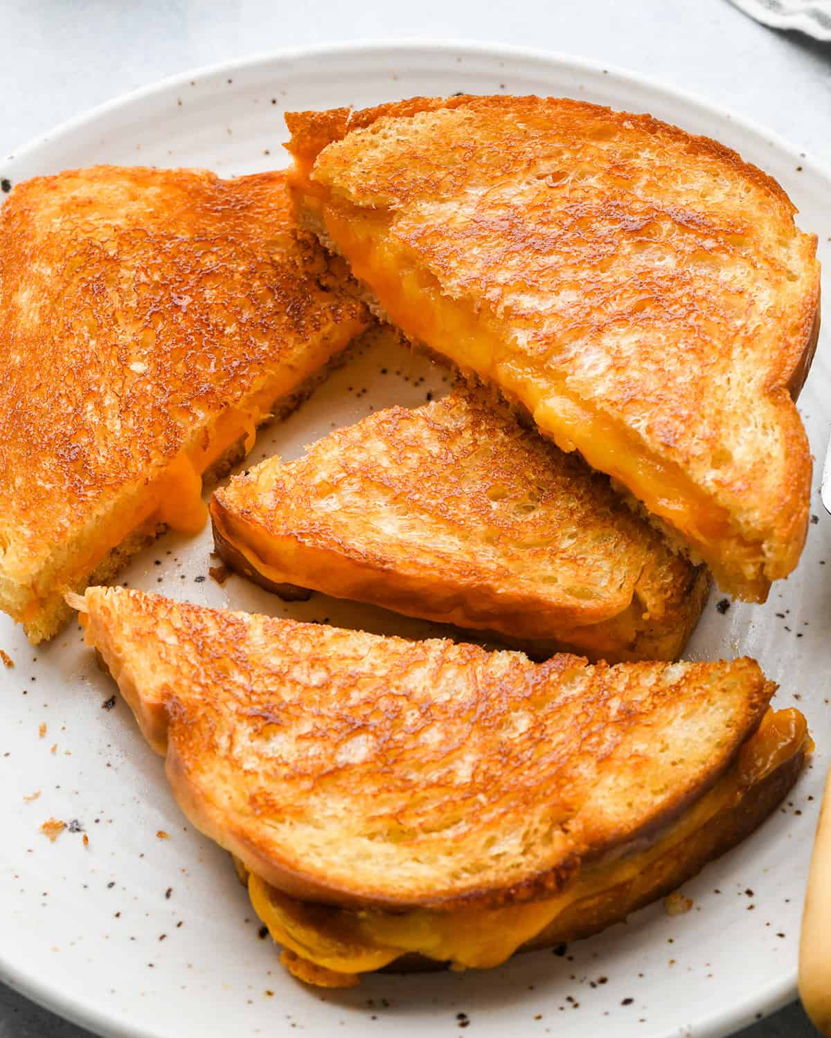 4 halves of grilled cheese on a plate