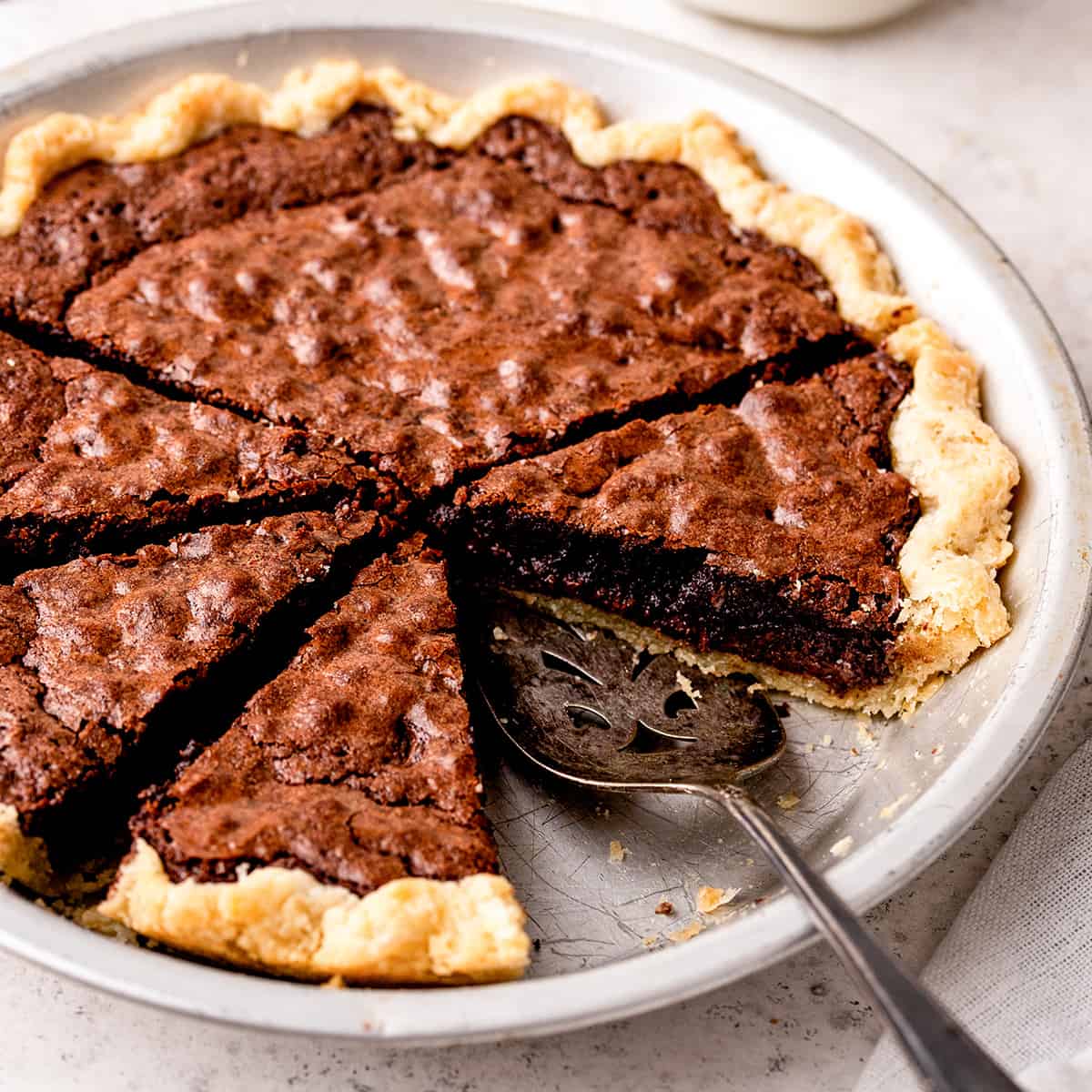 Brownie Pie in a pie dish with 4 slices cut out of it