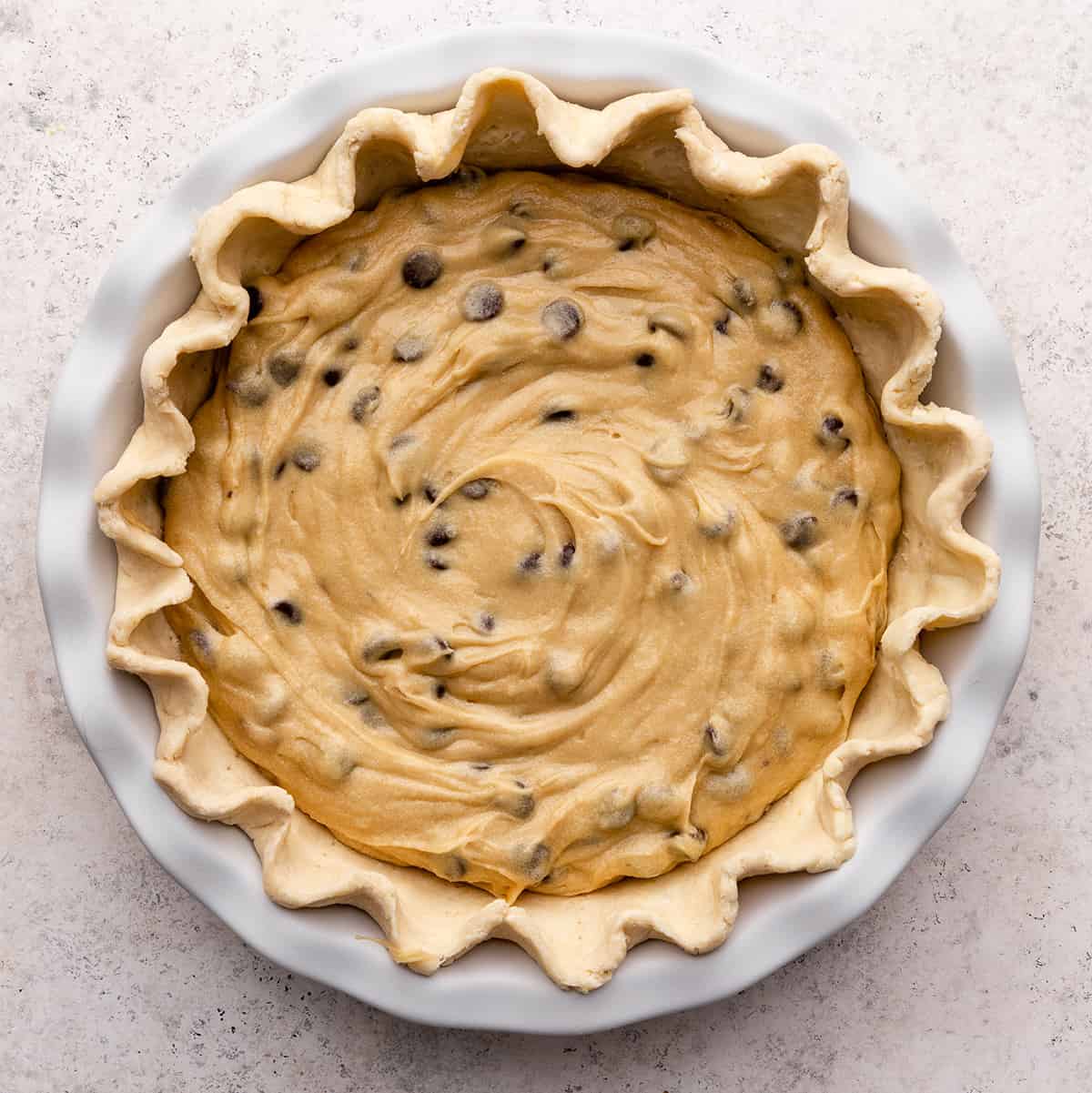 chocolate chip cookie pie in a pie dish before baking