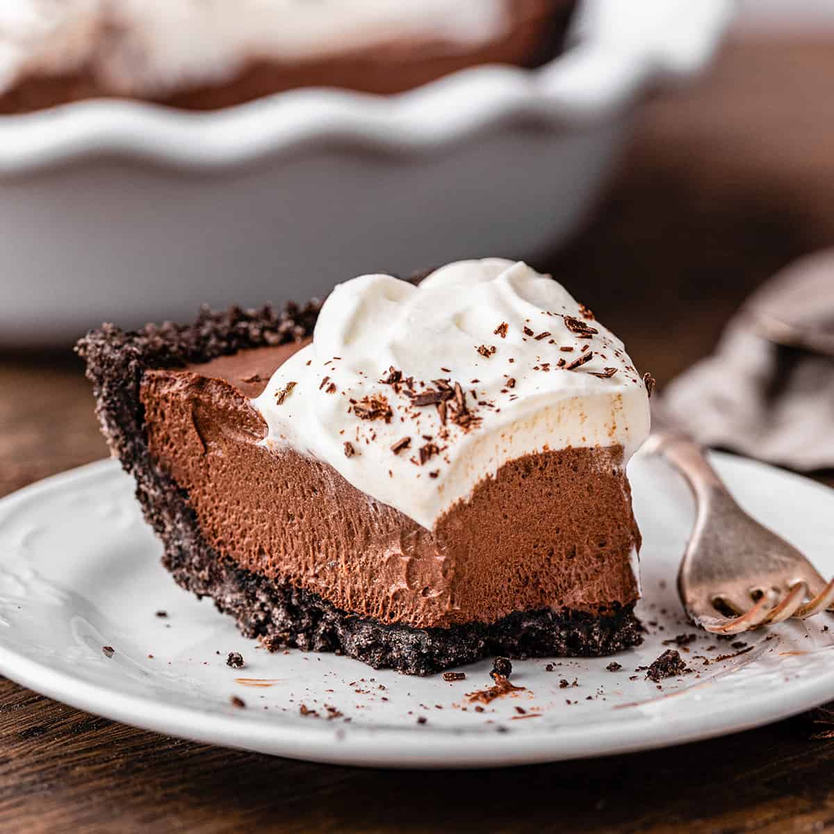 a slice of Chocolate Pudding Pie on a plate with a bite taken out of it