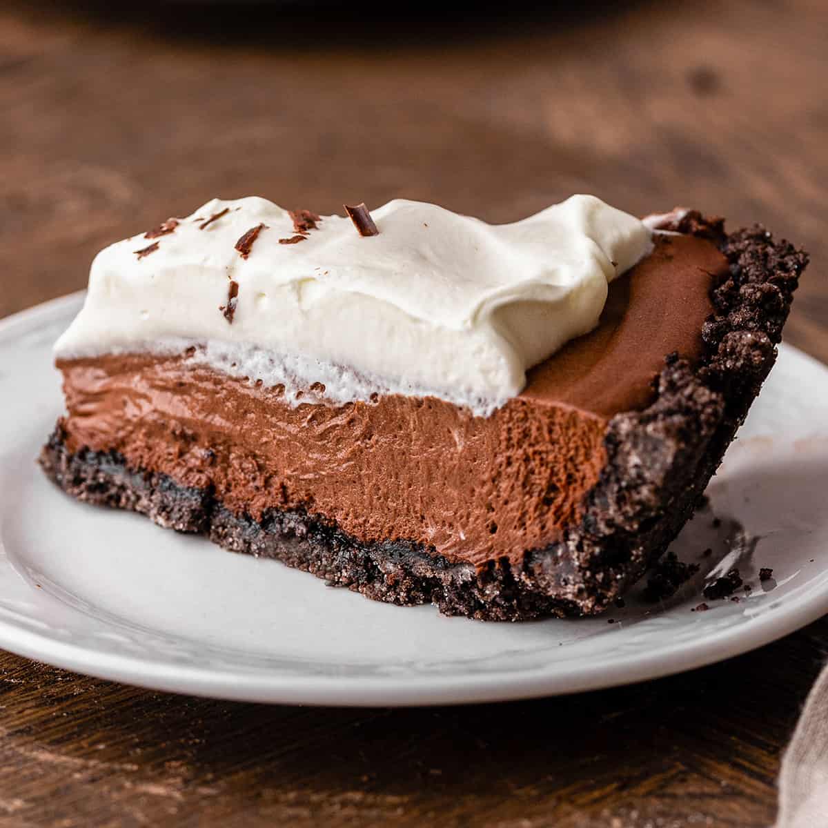 a slice of Chocolate Pudding Pie with shipped cream on a plate