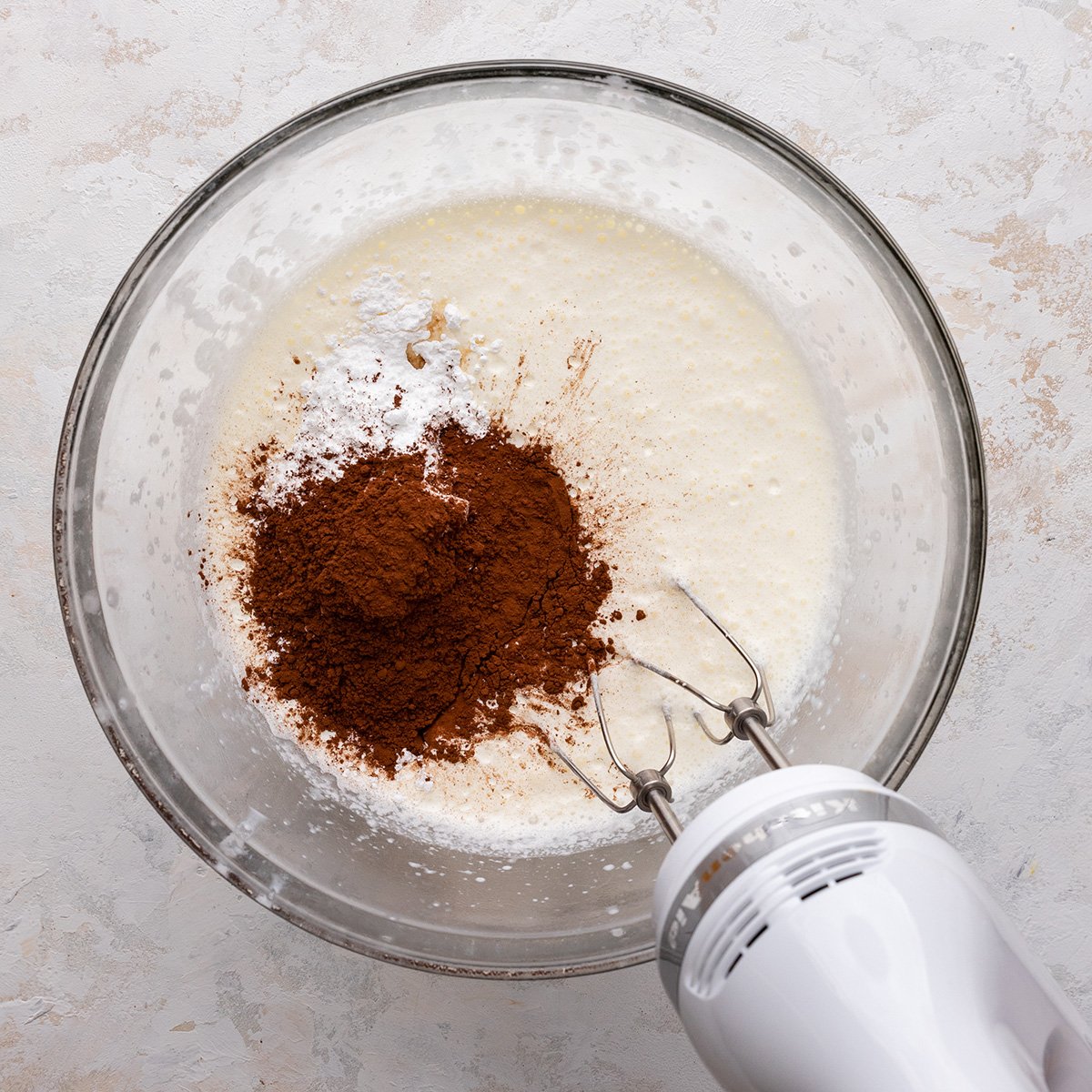 adding cocoa powder, powdered sugar and vanilla to the whipped cream to make Chocolate Whipped Cream