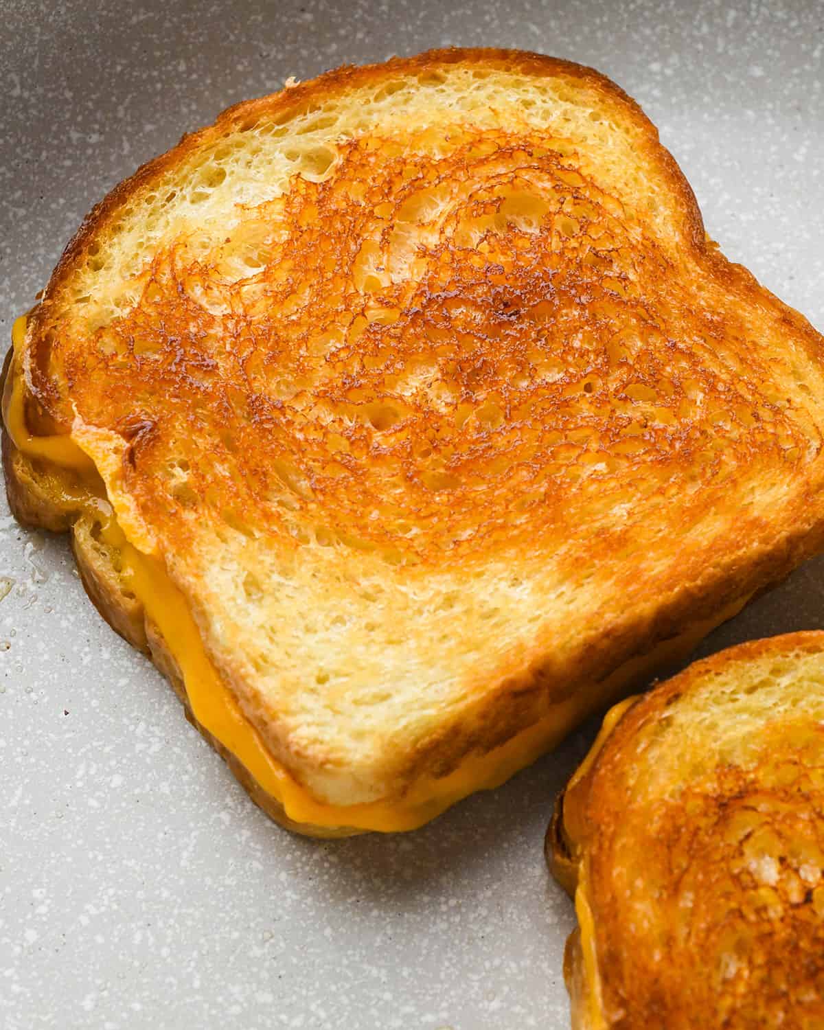 a cooked grilled cheese sandwich in a skillet
