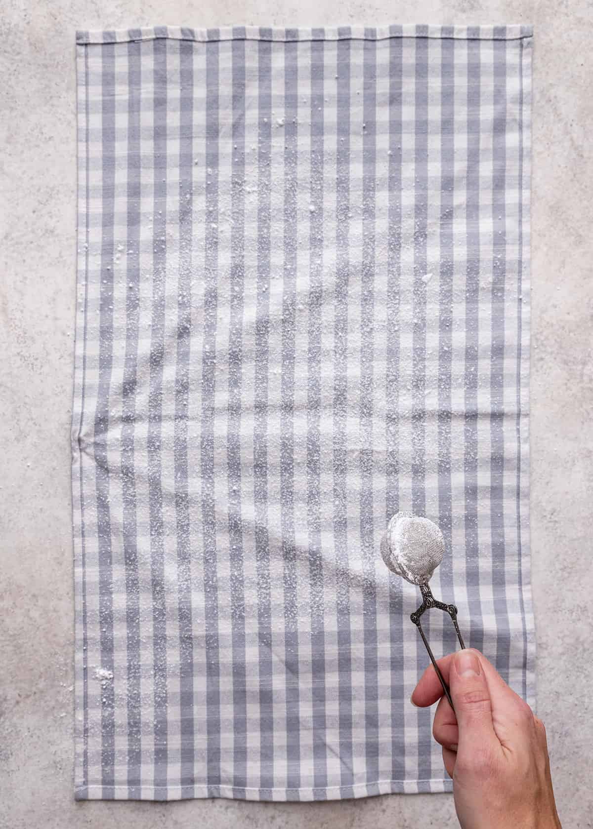 a tea towel being dusted with powdered sugar