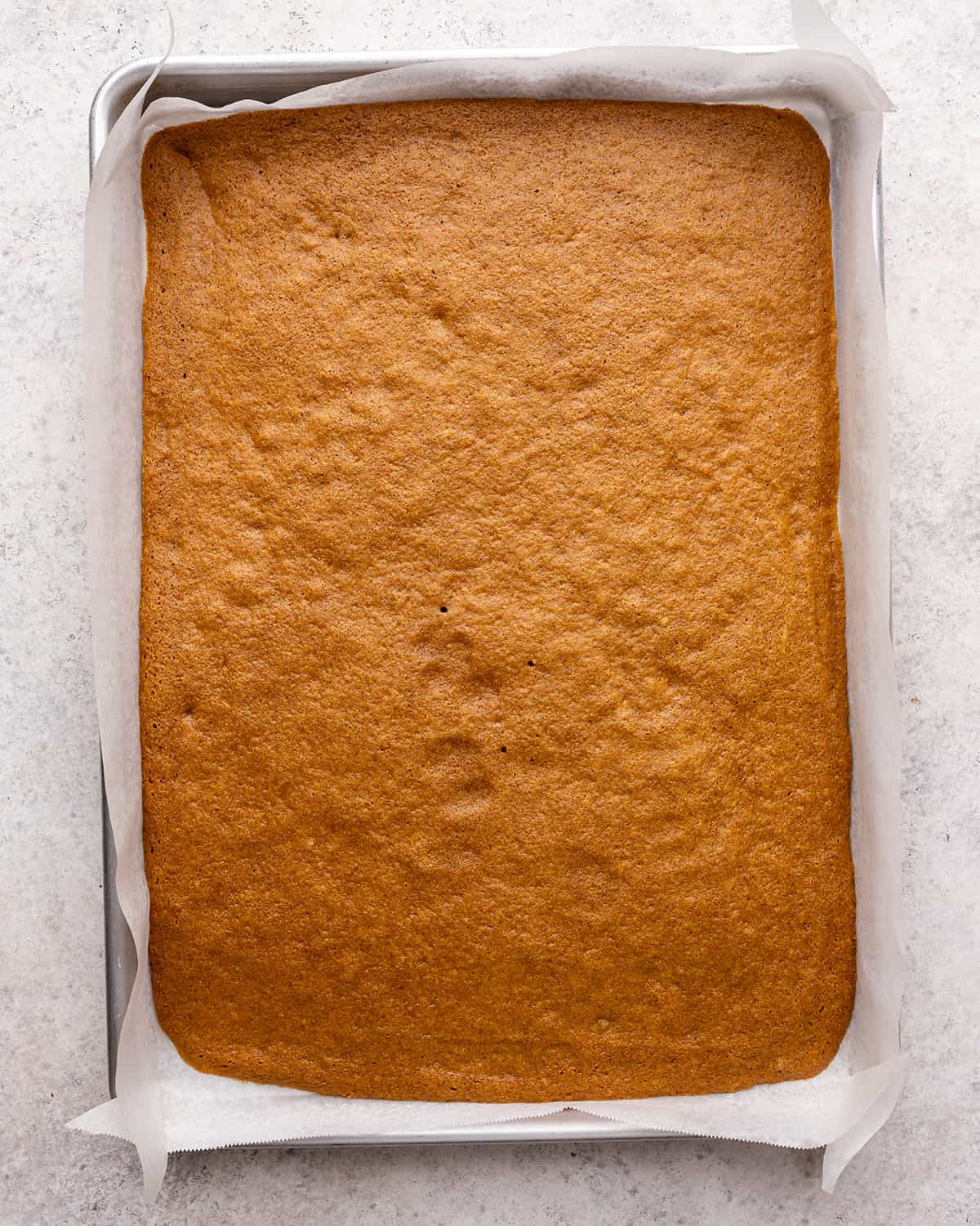 pumpkin roll cake in the baking pan after being baked