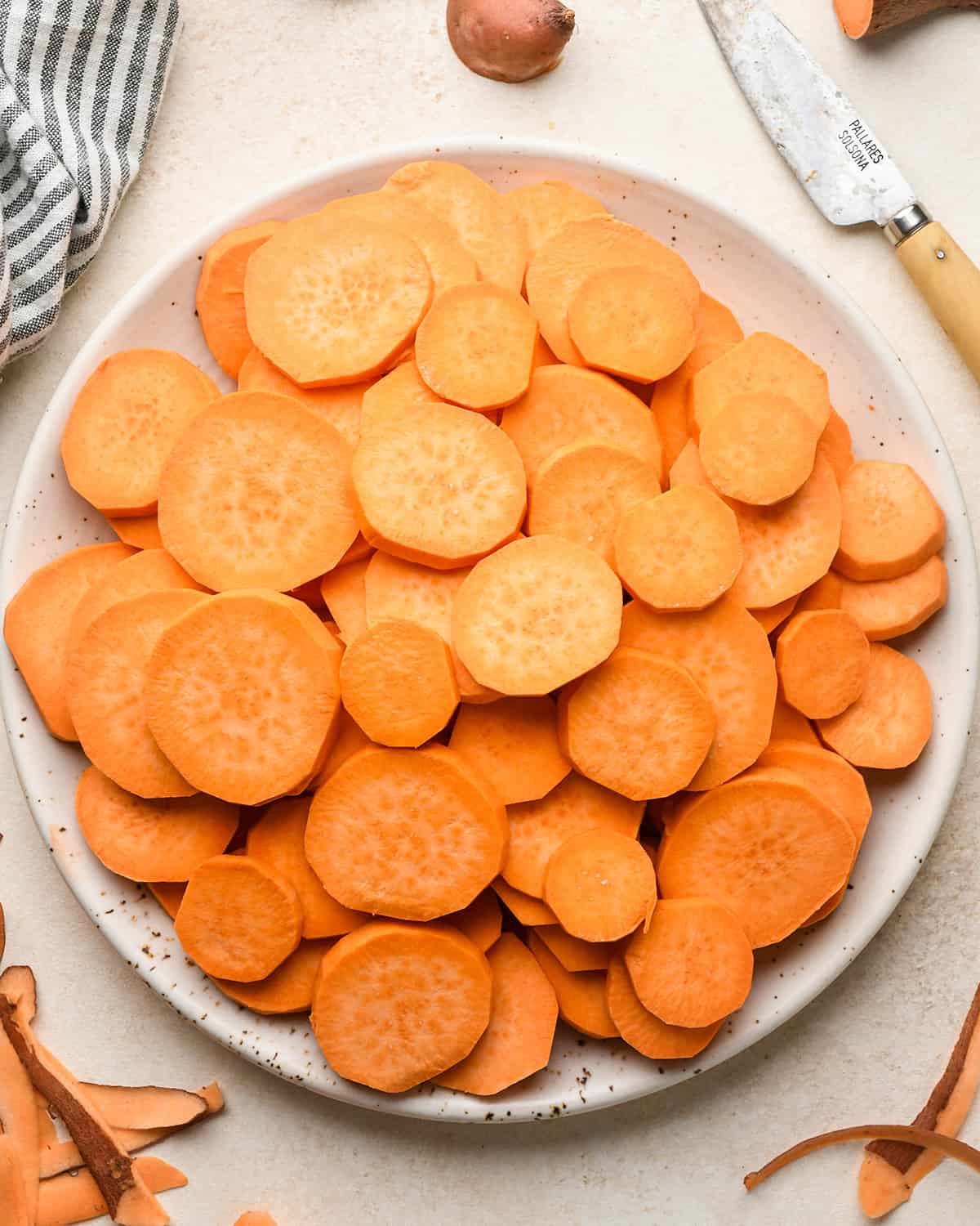 round slices of peeled sweet potatoes on a plate
