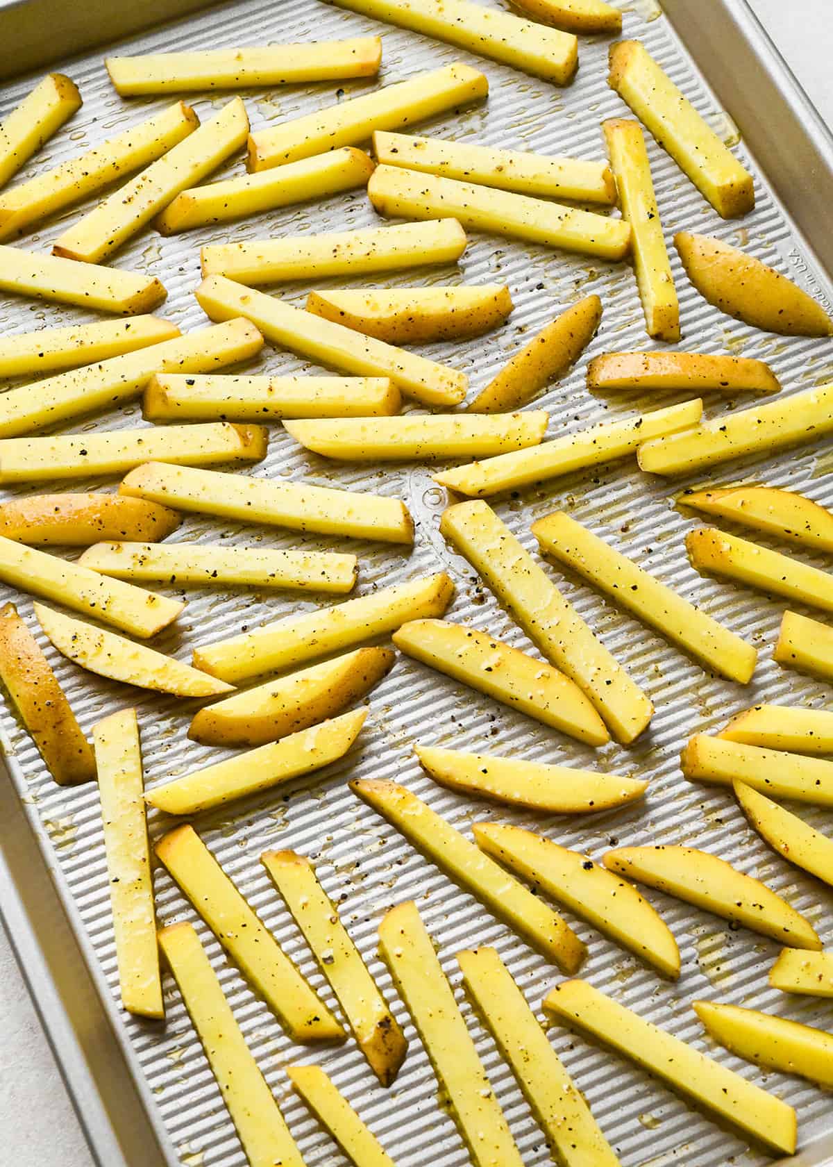 homemade fries on a baking sheet before being baked
