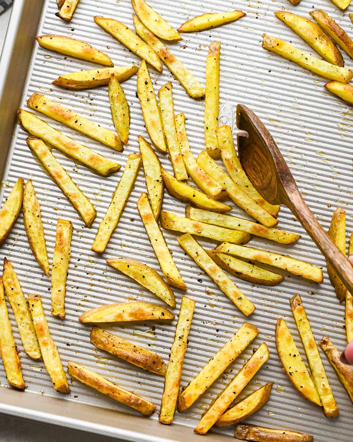 oven baked french fries on a baking sheet after baking