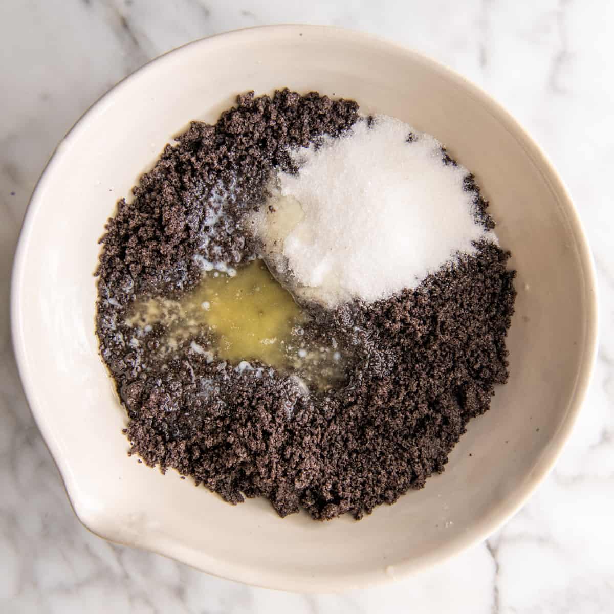 Oreo crumbs, butter and sugar in a mixing bowl