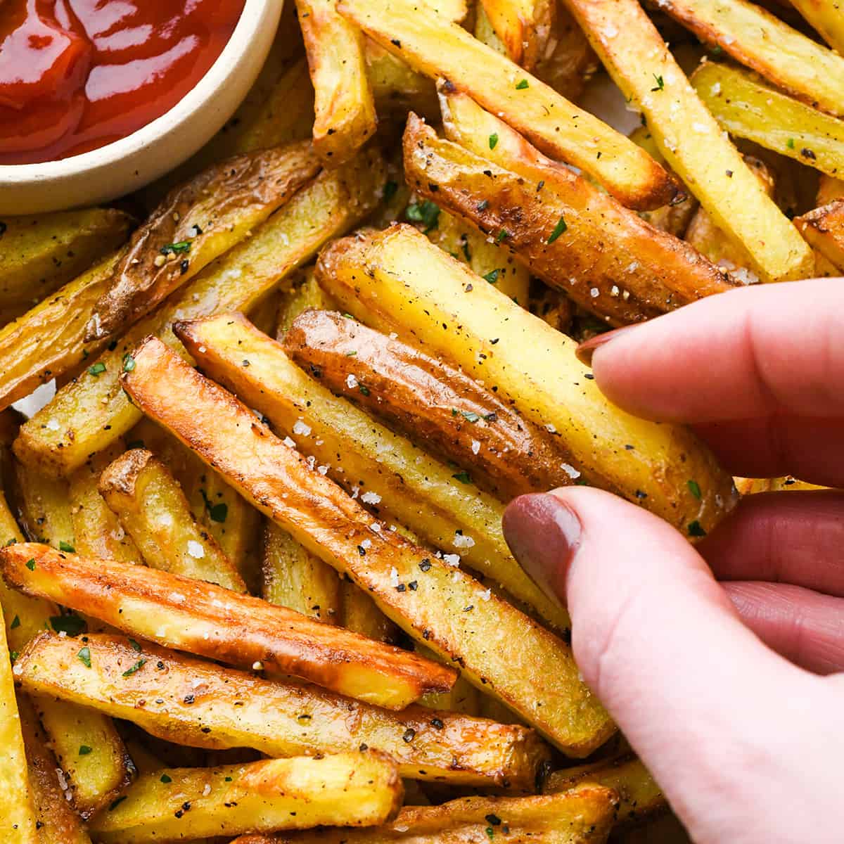 hands holding oven baked french fries 