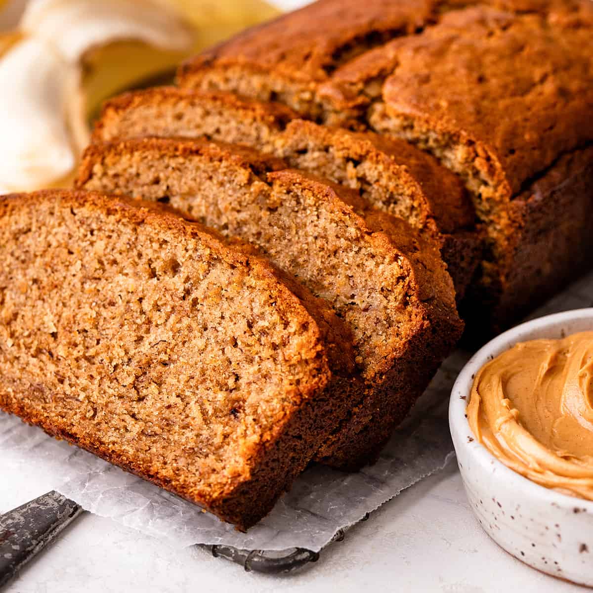 a loaf of Peanut Butter Banana Bread with 3 slices cut out of it