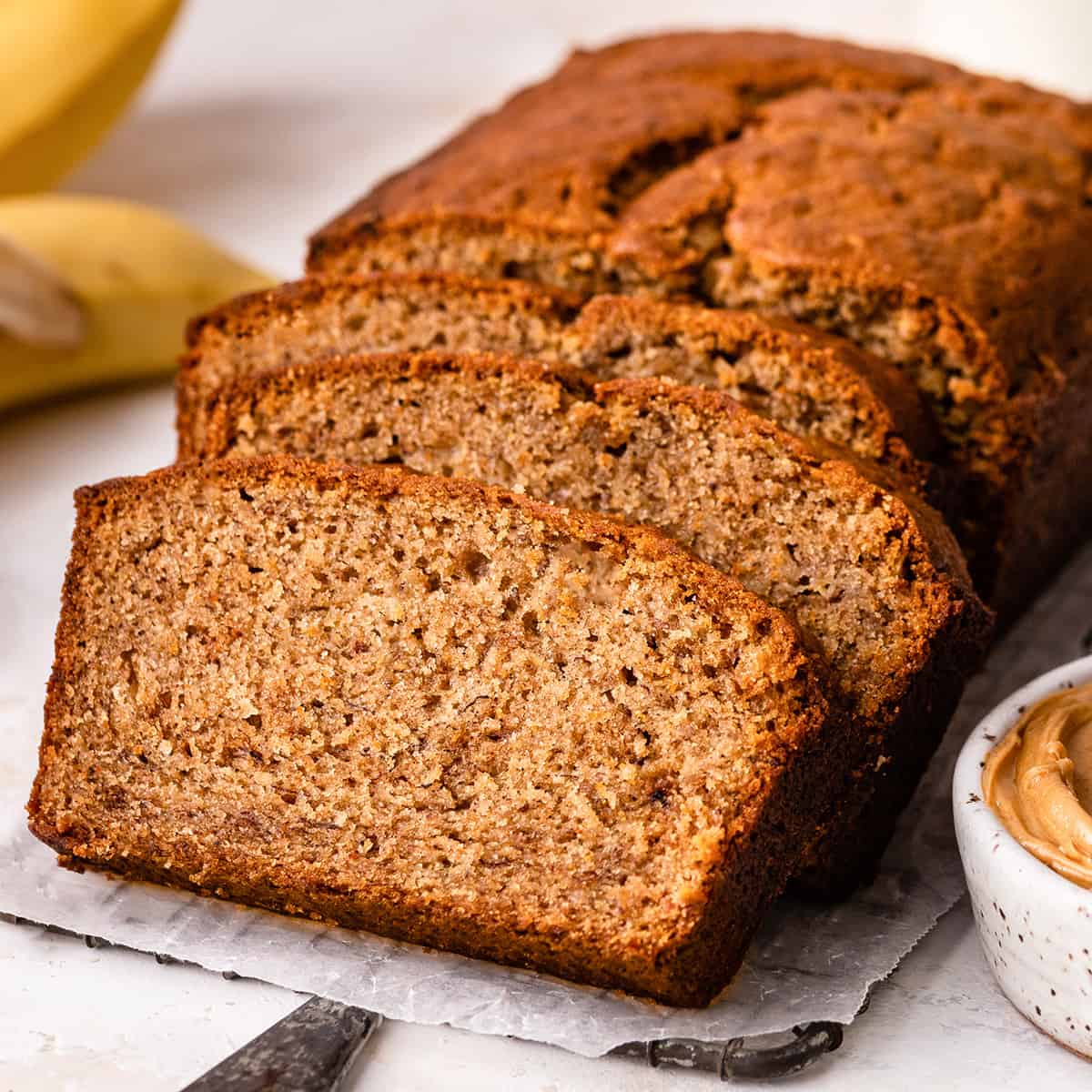a loaf of Peanut Butter Banana Bread with 3 slices cut out 