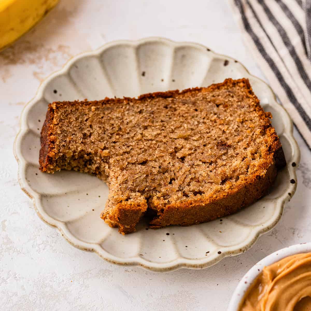 a slice of Peanut Butter Banana Bread on a plate with a bite taken out of it 