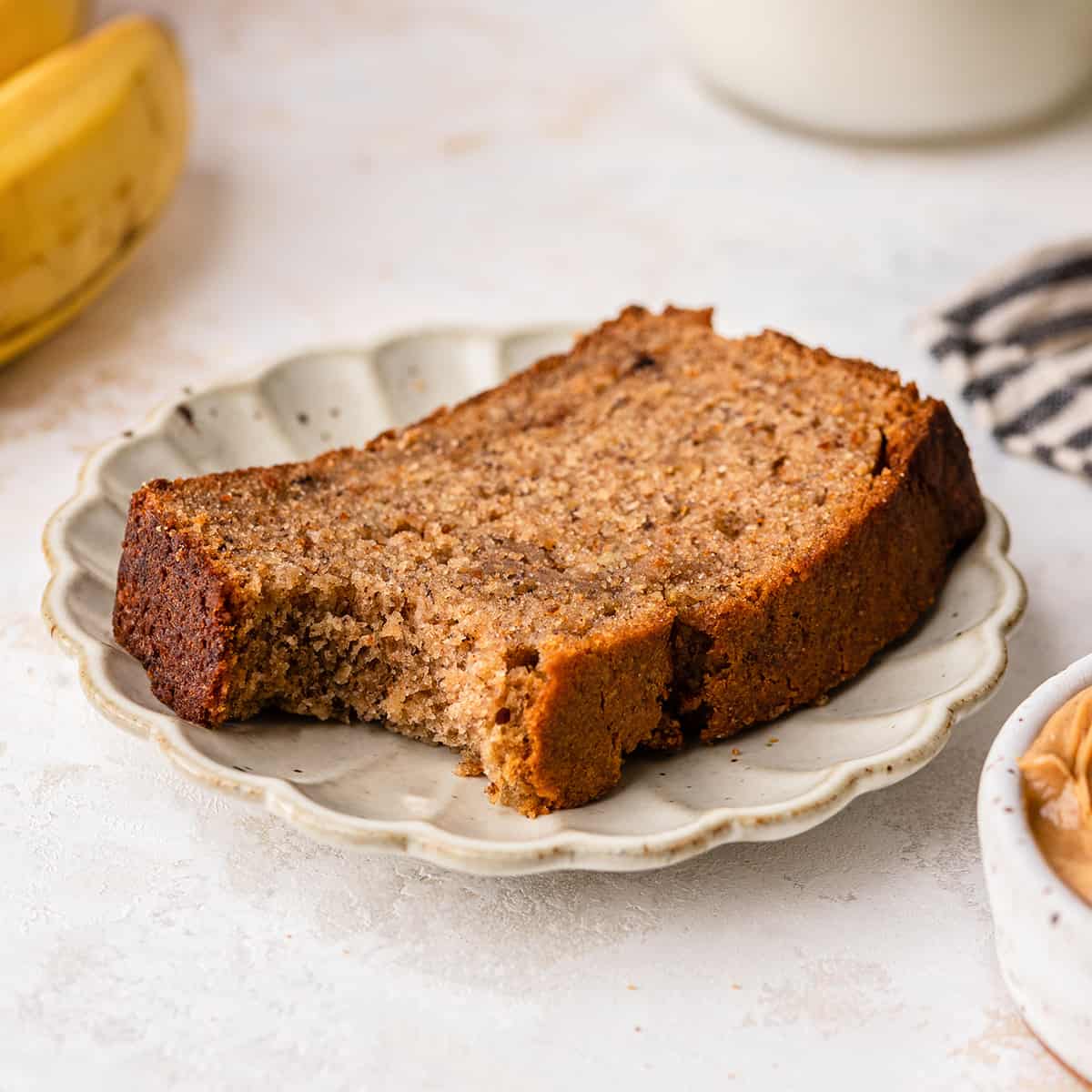 a slice of Peanut Butter Banana Bread on a plate with a bite taken out of it